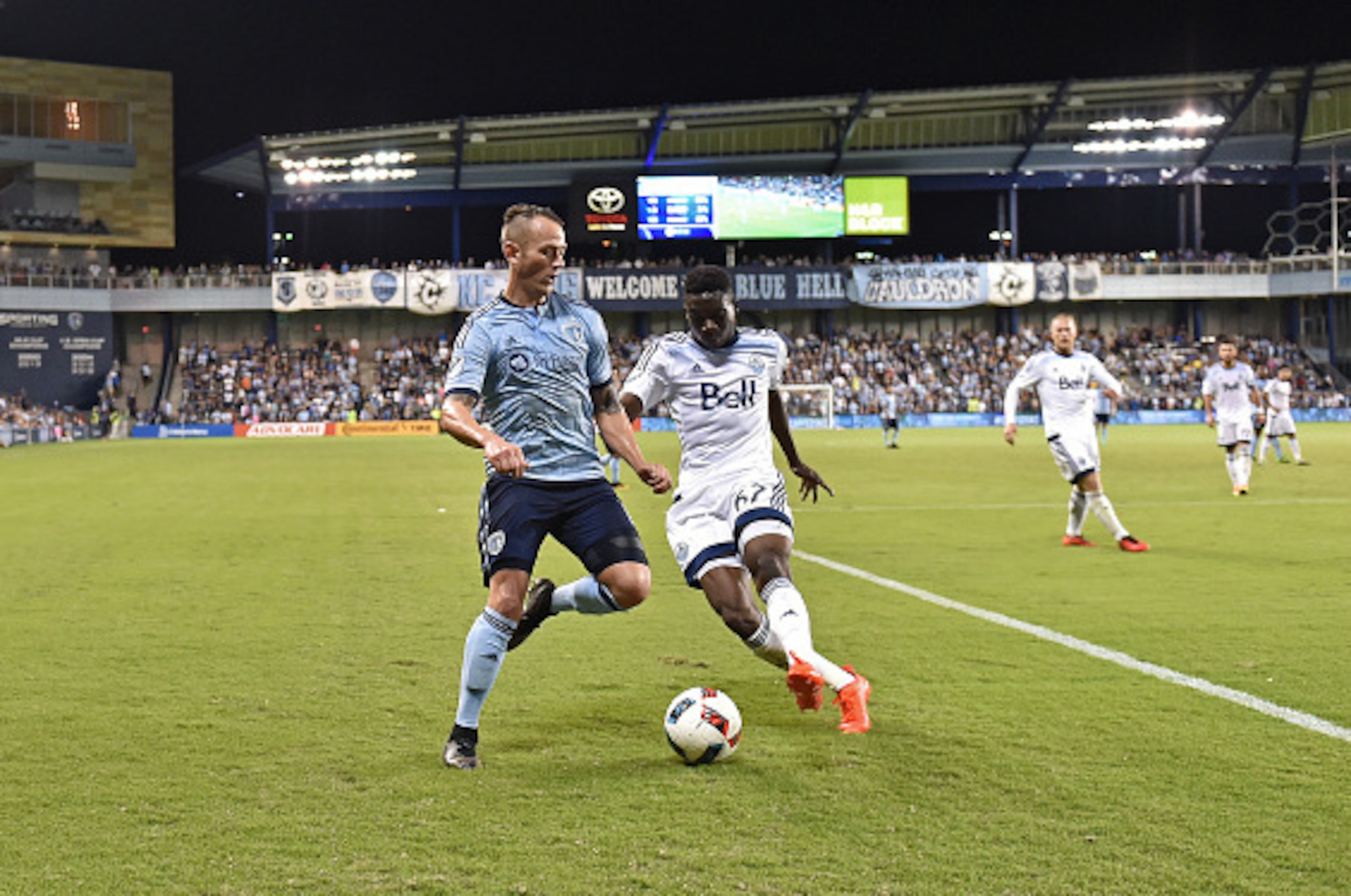 KANSAS CITY, KS - AUGUST 20:  Mid-fielder Brad Davis #11 of Sporting Kansas City dribbles the ball against defender Alphonso Davies #67 of the Vancouver Whitecaps FC during the second half on August 20, 2016 at Children's Mercy Park in Kansas City, Kansas