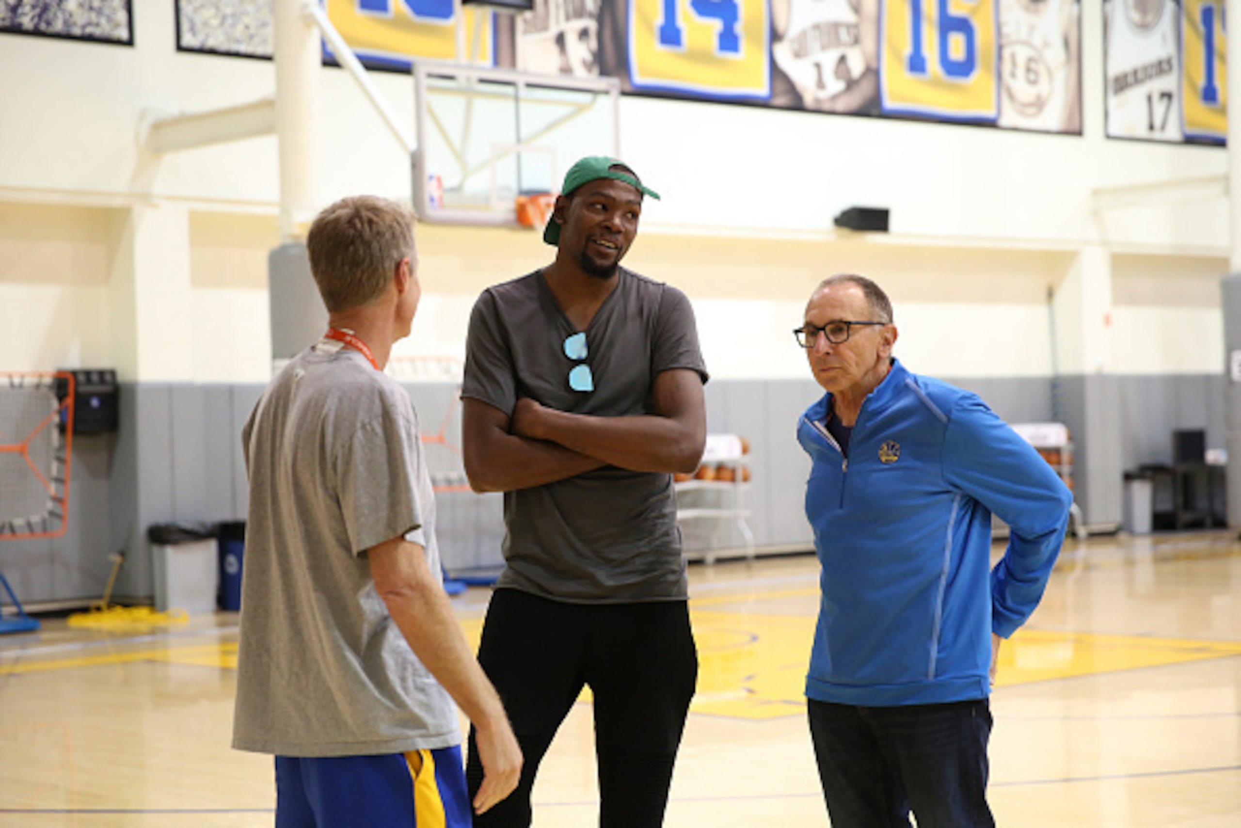 OAKLAND, CA - JULY 7:  Head coach Steve Kerr of the Golden State Warriors, assistant coach Ron Adams and Kevin Durant talk before the press conference to introduce Kevin Durant on July 7, 2016 in Oakland, California. NOTE TO USER: User expressly acknowled