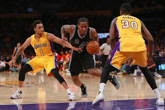 LOS ANGELES, CA - JANUARY 22: Kawhi Leonard #2 of the San Antonio Spurs dribbles to the basket against D'Angelo Russell #1 and Julius Randle #30 of the Los Angeles Lakers in the second half during the NBA game at Staples Center on January 22, 2016 in Los 