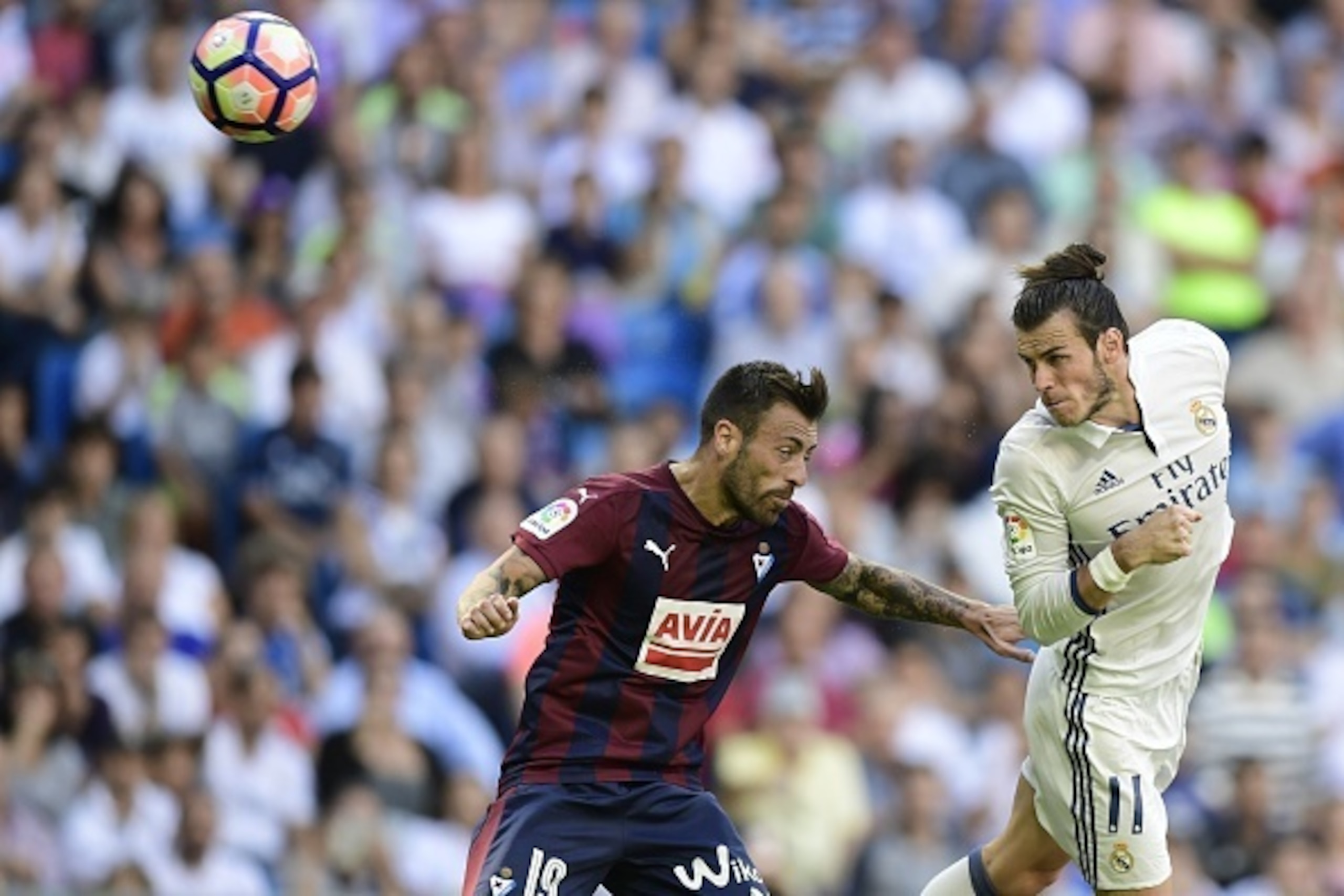 Eibar's defender Antonio Luna (L) vies with Real Madrid's Welsh forward Gareth Bale during the Spanish league football match Real Madrid CF vs SD Eibar at the Santiago Bernabeu stadium in Madrid on October 2, 2016. / AFP / JAVIER SORIANO        (Photo cre