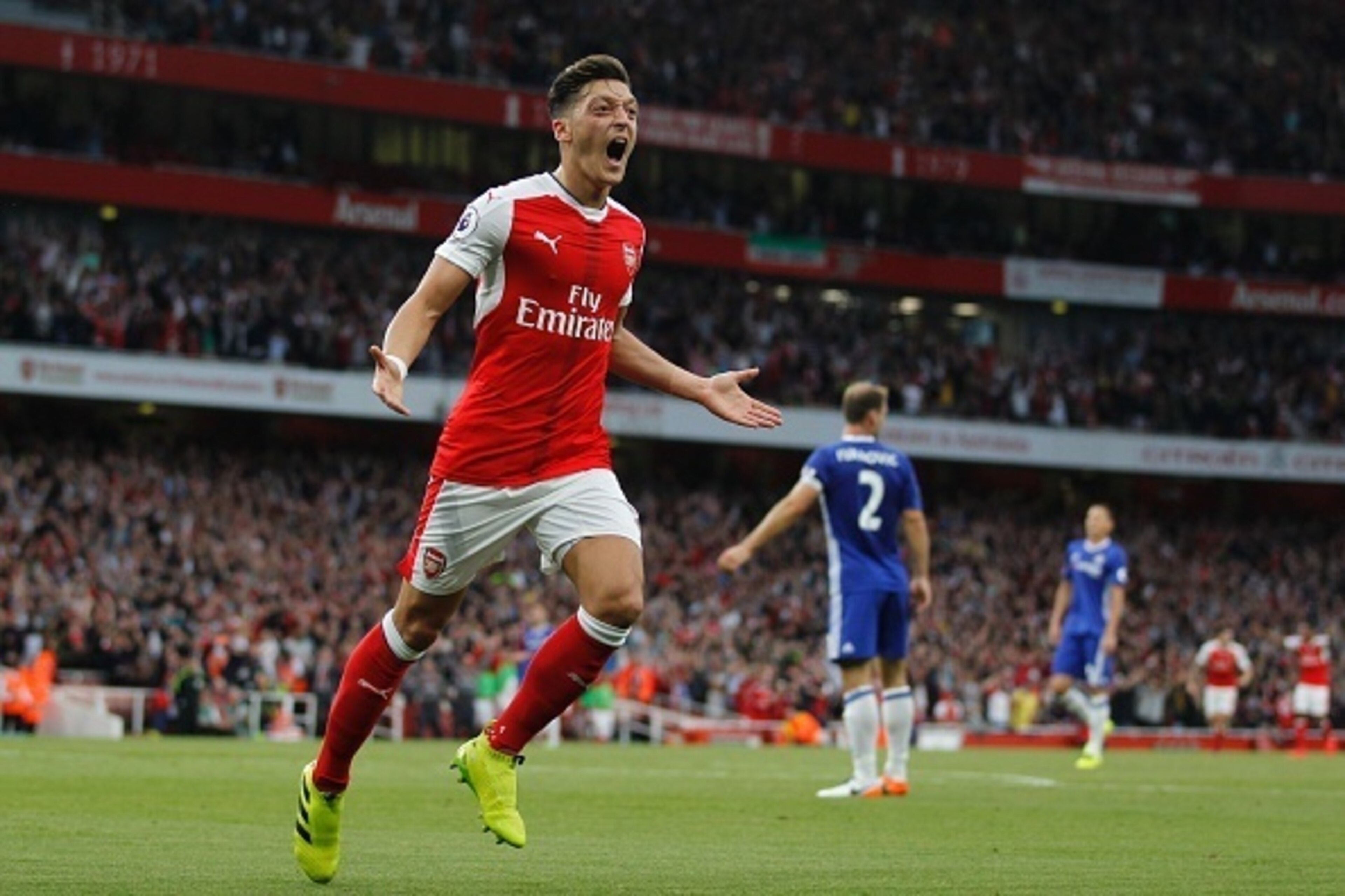 Arsenal's German midfielder Mesut Ozil celebrates scoring their third goal during the English Premier League football match between Arsenal and Chelsea at The Emirates stadium in London, on September 24, 2016. / AFP / IKIMAGES / Ian Kington / RESTRICTED T