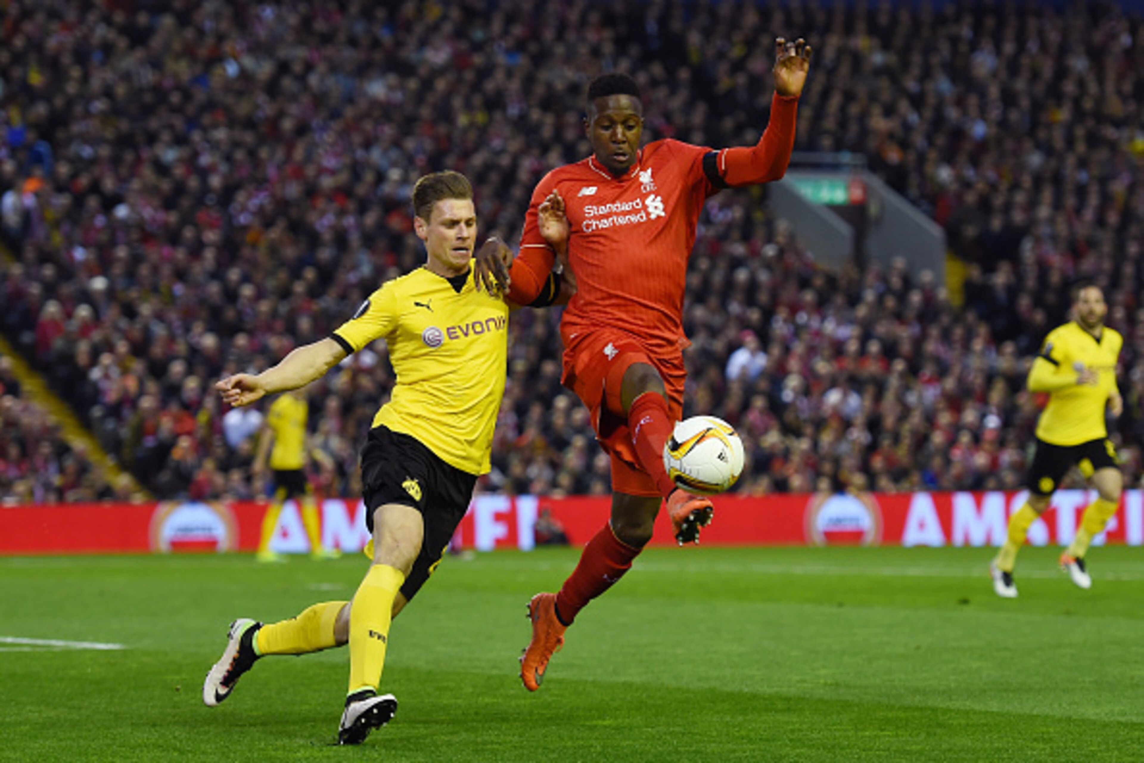 LIVERPOOL, ENGLAND - APRIL 14:  Divock Origi of Liverpool challenges for the ball with Lukasz Piszczek of Borussia Dortmund during the UEFA Europa League quarter final, second leg match between Liverpool and Borussia Dortmund at Anfield on April 14, 2016 