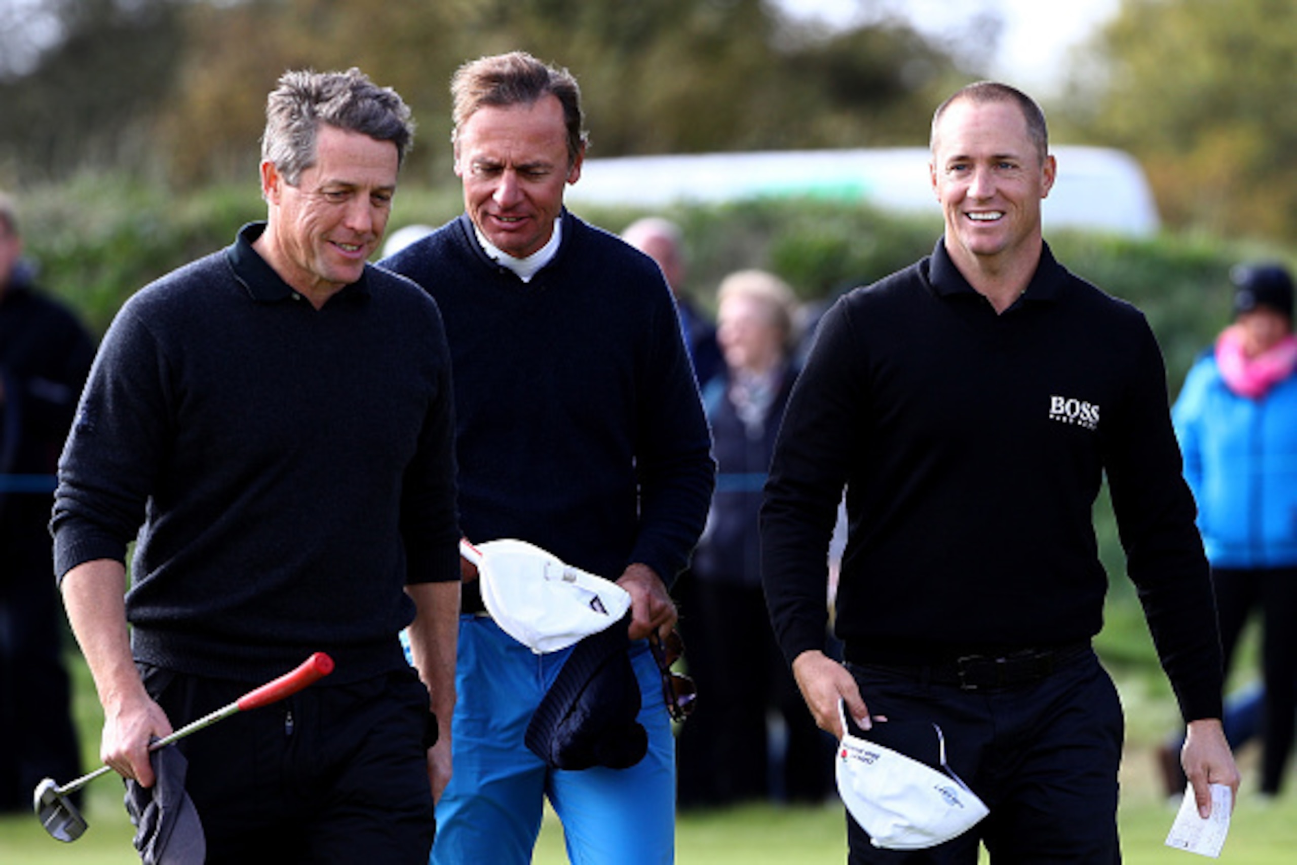 CARNOUSTIE, SCOTLAND - OCTOBER 06:  Alex Noren of Sweden celebrates with his playing partner Ernesto Bertarelli and Hugh Grant after finishing his round on the nineth green during the first round of the Alfred Dunhill Links Championship on the Championshi