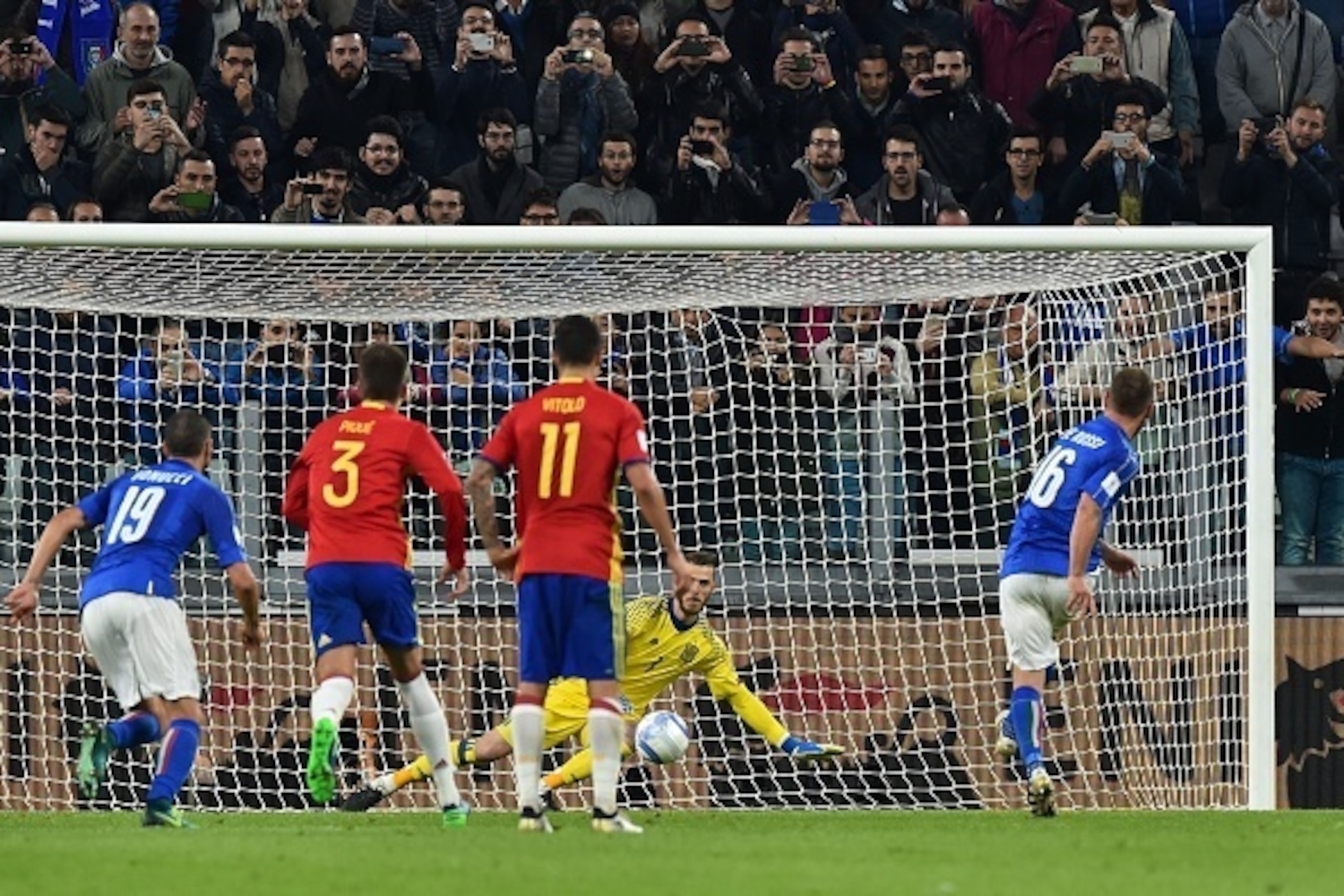 Italy's midfielder Daniele De Rossi (R) kicks and scores a penalty against Spain's goalkeeper David de Gea during the WC 2018 football qualification match between Italy and Spain on October 6, 2016 at the Juventus stadium in Turin / AFP / GIUSEPPE CACACE 