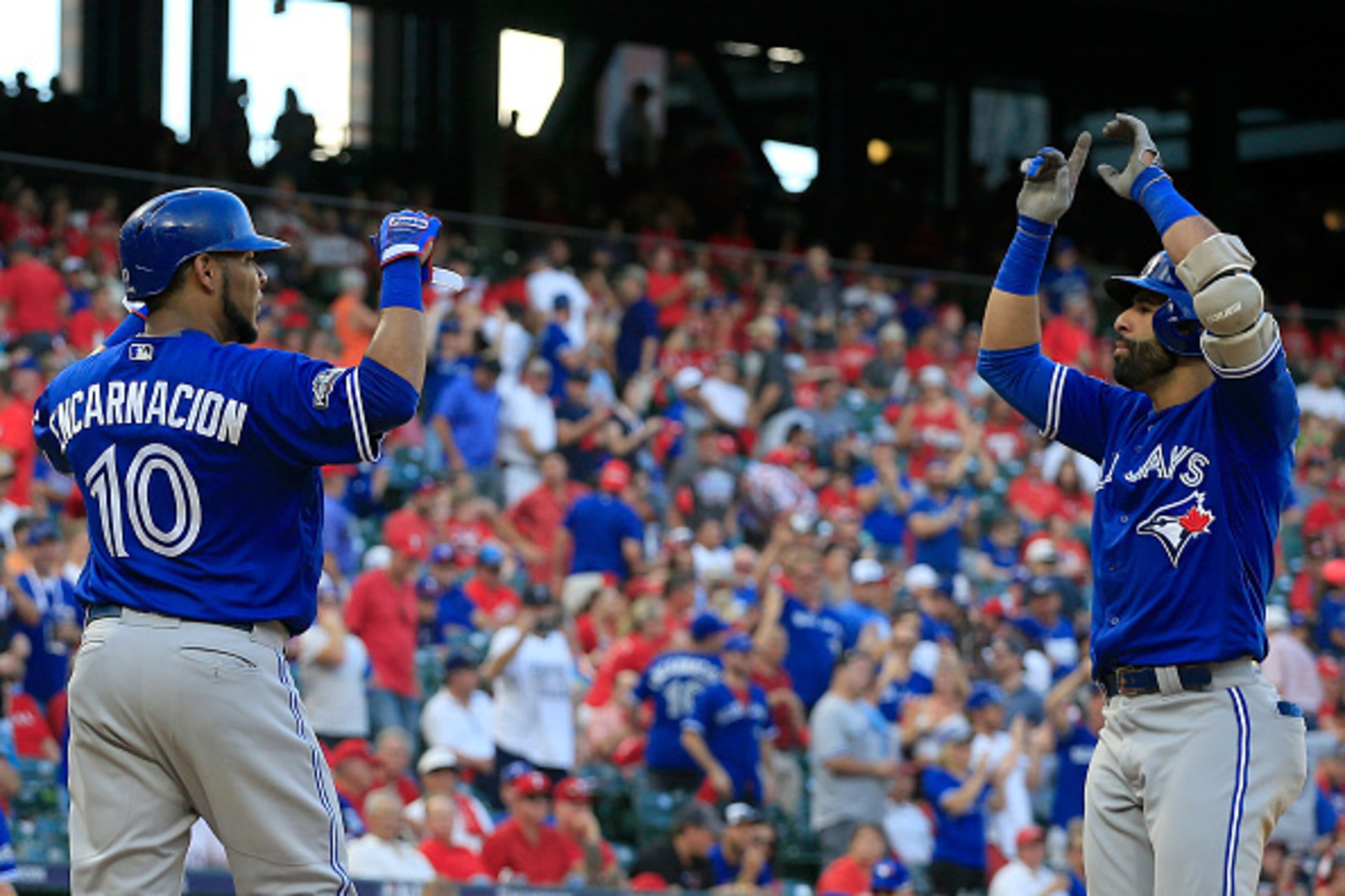ARLINGTON, TX - OCTOBER 06:  Jose Bautista #19 of the Toronto Blue Jays celebrates with Edwin Encarnacion #10 after hitting a three run home run to left field agianst Jake Diekman #41 of the Texas Rangers during the ninth inning in game one of the America