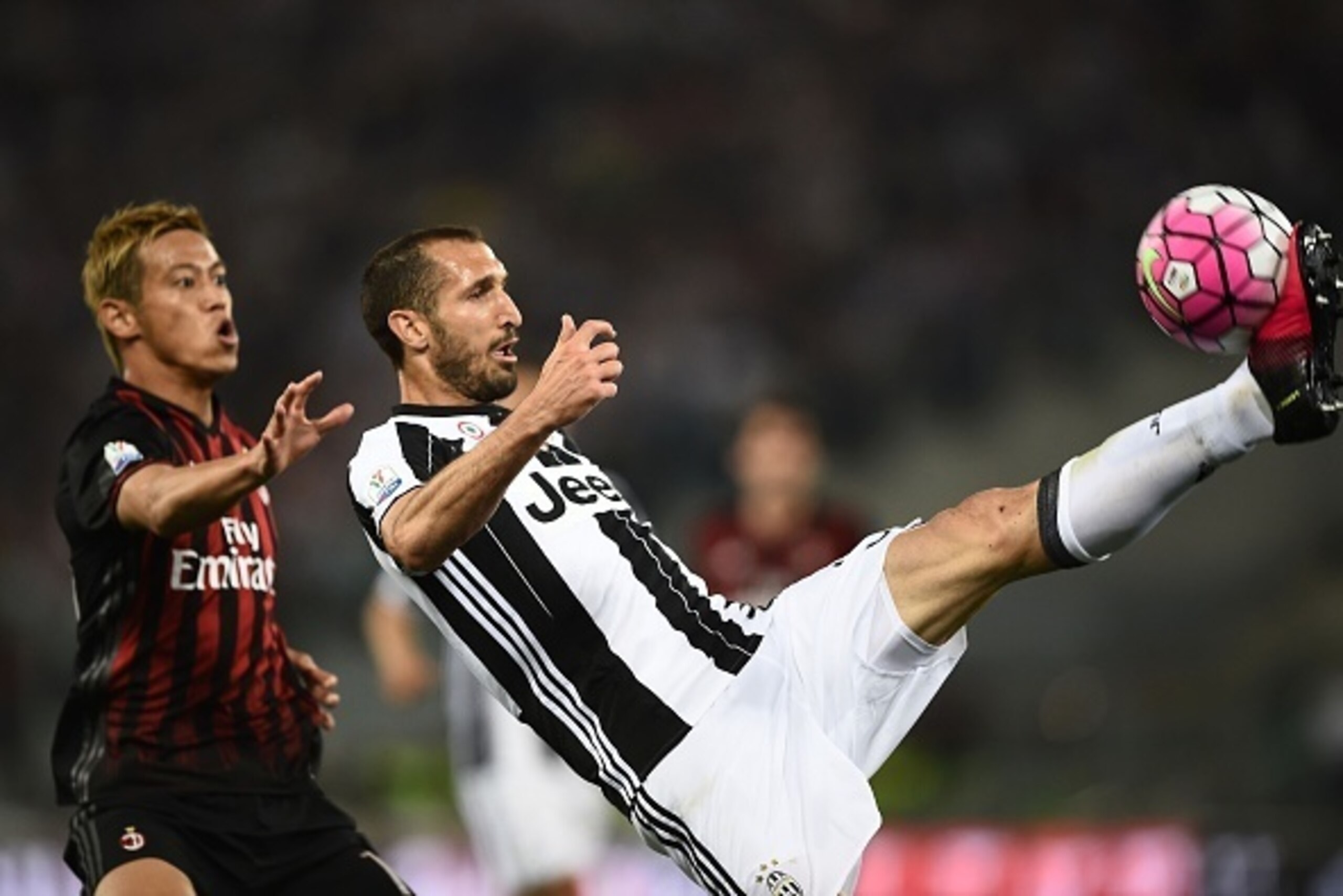 AC Milan's midfielder from Japan Keisuke Honda (L) fights for the ball with Juventus' defender from Italy Giorgio Chiellini during the Italian Tim Cup final football match AC Milan vs Juventus on May 21, 2016 at the Olympic Stadium in Rome.    AFP PHOTO /