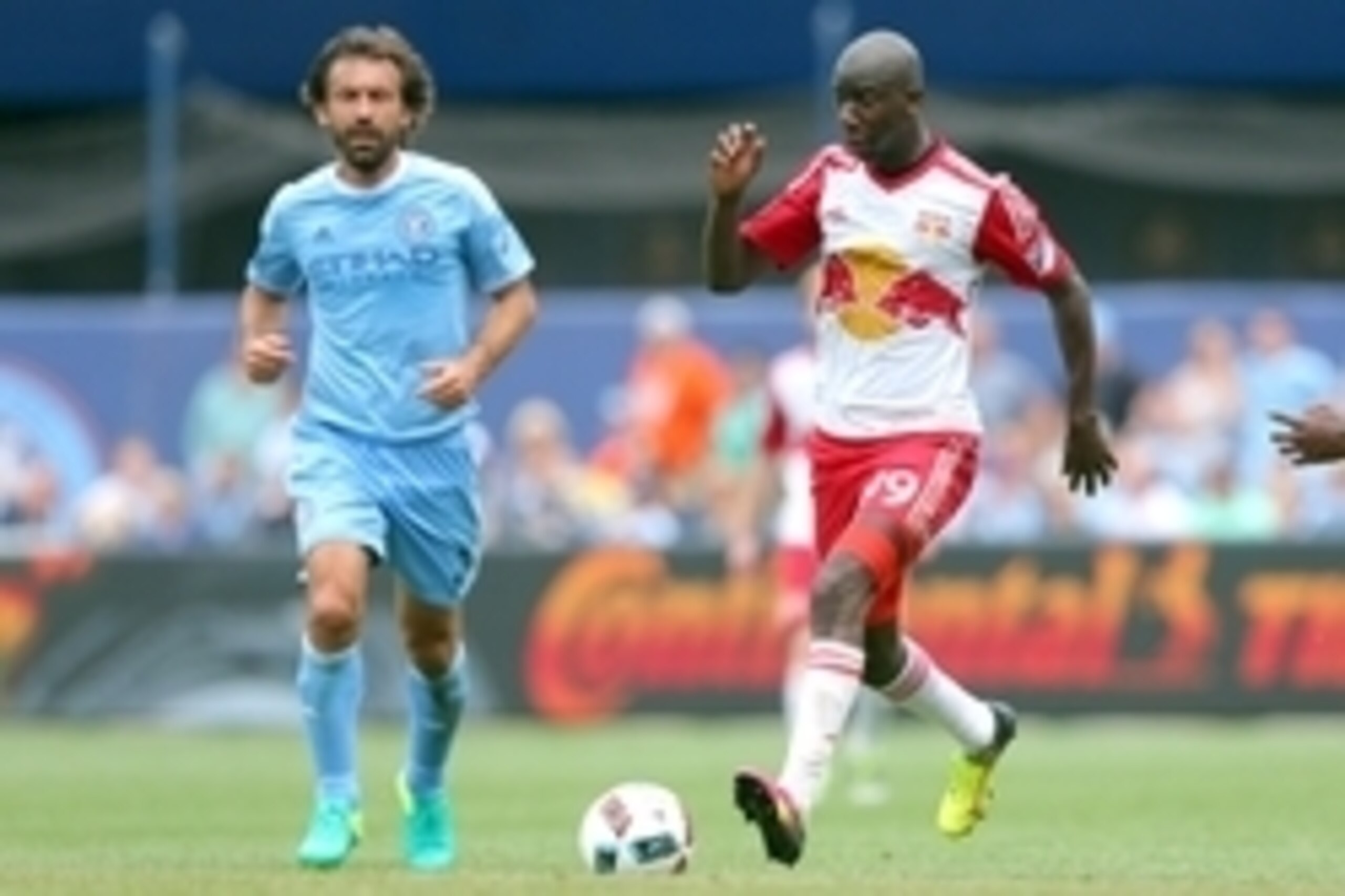 Jul 3, 2016; New York, NY, USA; New York Red Bulls forward Bradley Wright-Phillips (99) controls the ball against New York City FC midfielder Andrea Pirlo (21) during the second half at Yankee Stadium. Mandatory Credit: Brad Penner-USA TODAY Sports