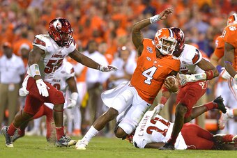 CLEMSON, SC - OCTOBER 01: Deshaun Watson #4 of the Clemson Tigers looks to avoid the tackle of Keith Kelsey #55 and Josh Harvey-Clemons #25 of the Louisville Cardinals during the third quarter at Memorial Stadium on October 1, 2016 in Clemson, South Carol