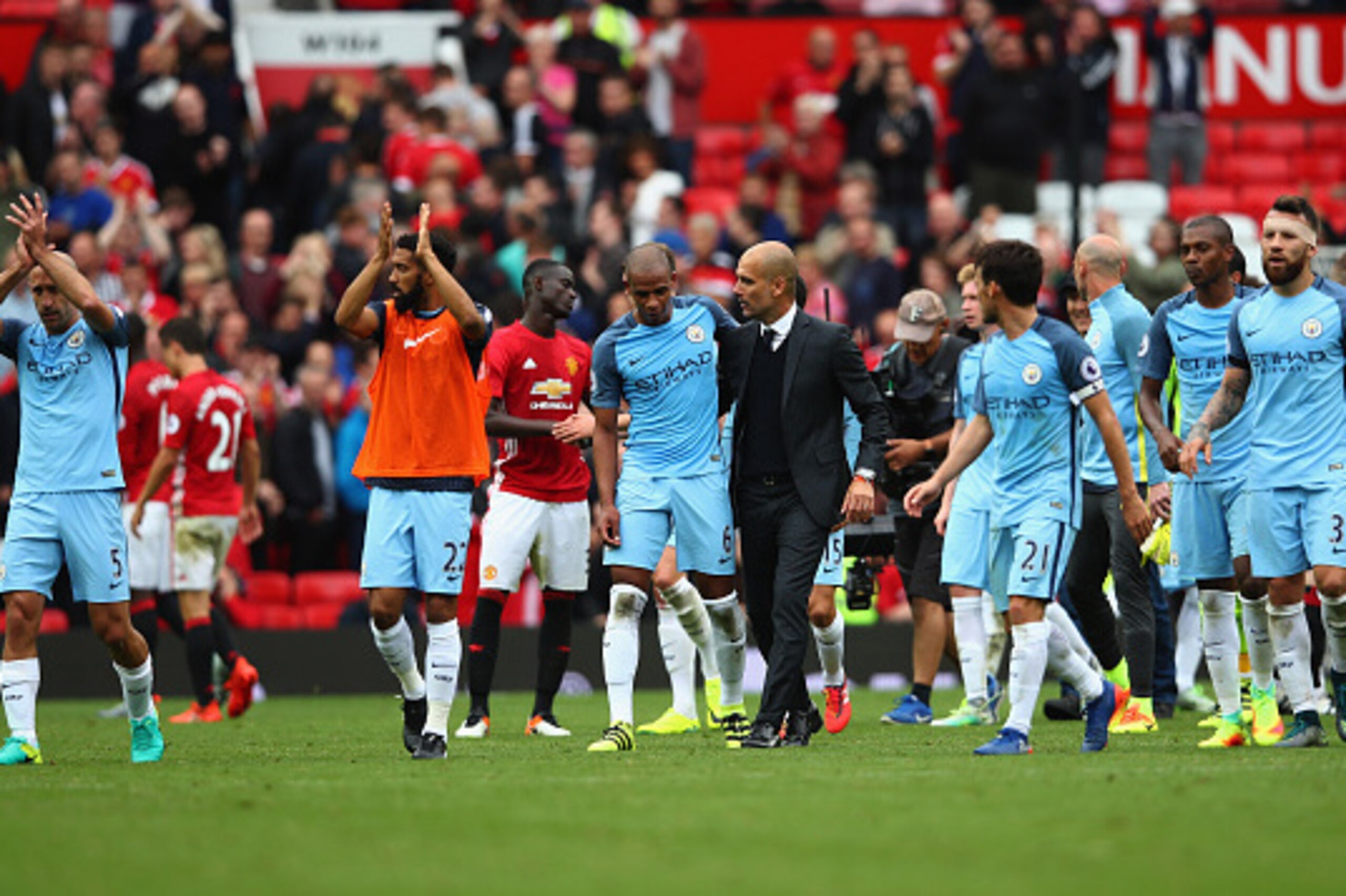 MANCHESTER, ENGLAND - SEPTEMBER 10:  Manchester City manager Pep Guardiola celebrates with Fernando and his team after the final whistle of the Premier League match between Manchester United and Manchester City at Old Trafford on September 10, 2016 in Man