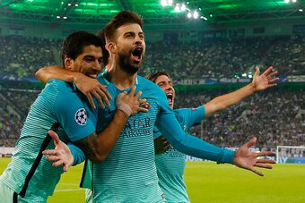 Barcelona's defender Gerard Pique (C) celebrates scoring the 1-2 goal with his teammates during the UEFA Champions League first-leg group C football match between Borussia Moenchengladbach and FC Barcelona at the Borussia Park in Moenchengladbach, western