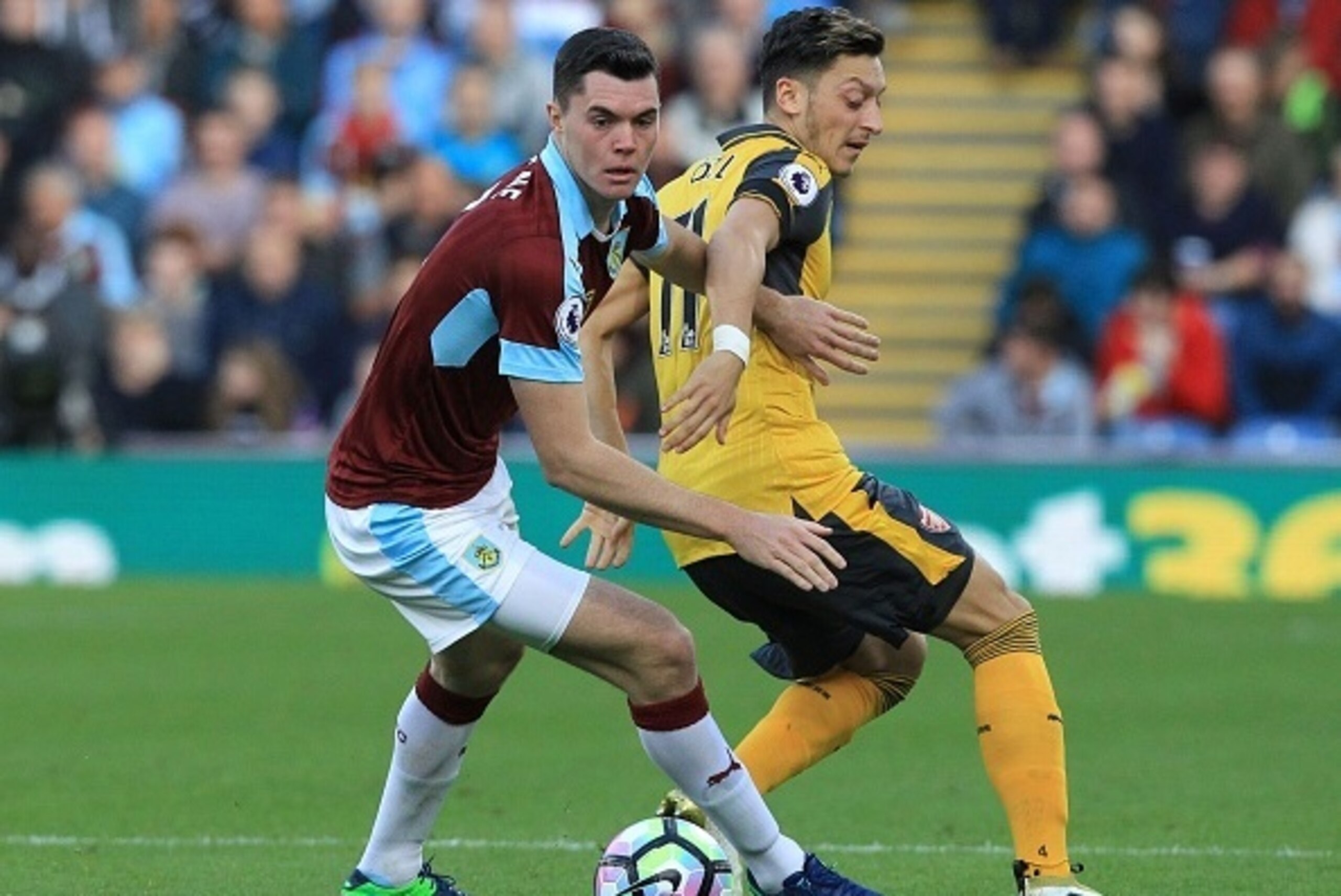 Burnley's English defender Michael Keane (L) vies with Arsenal's German midfielder Mesut Ozil during the English Premier League football match between Burnley and Arsenal at Turf Moor in Burnley, north west England on October 2, 2016. / AFP / Lindsey PARN