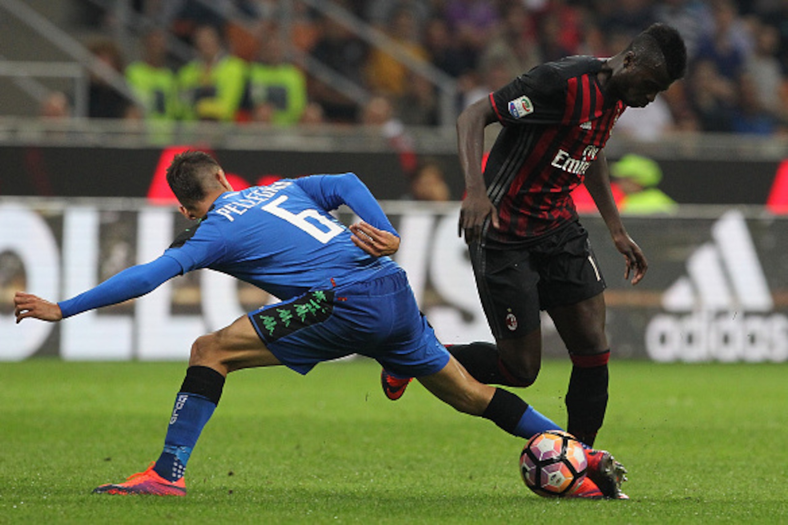 MILAN, ITALY - OCTOBER 02:  MÕ Baye Niang (R) of AC Milan is challenged by Lorenzo Pellegrini (L) of US Sassuolo during the Serie A match between AC Milan and US Sassuolo at Stadio Giuseppe Meazza on October 2, 2016 in Milan, Italy.  (Photo by Marco Luzza