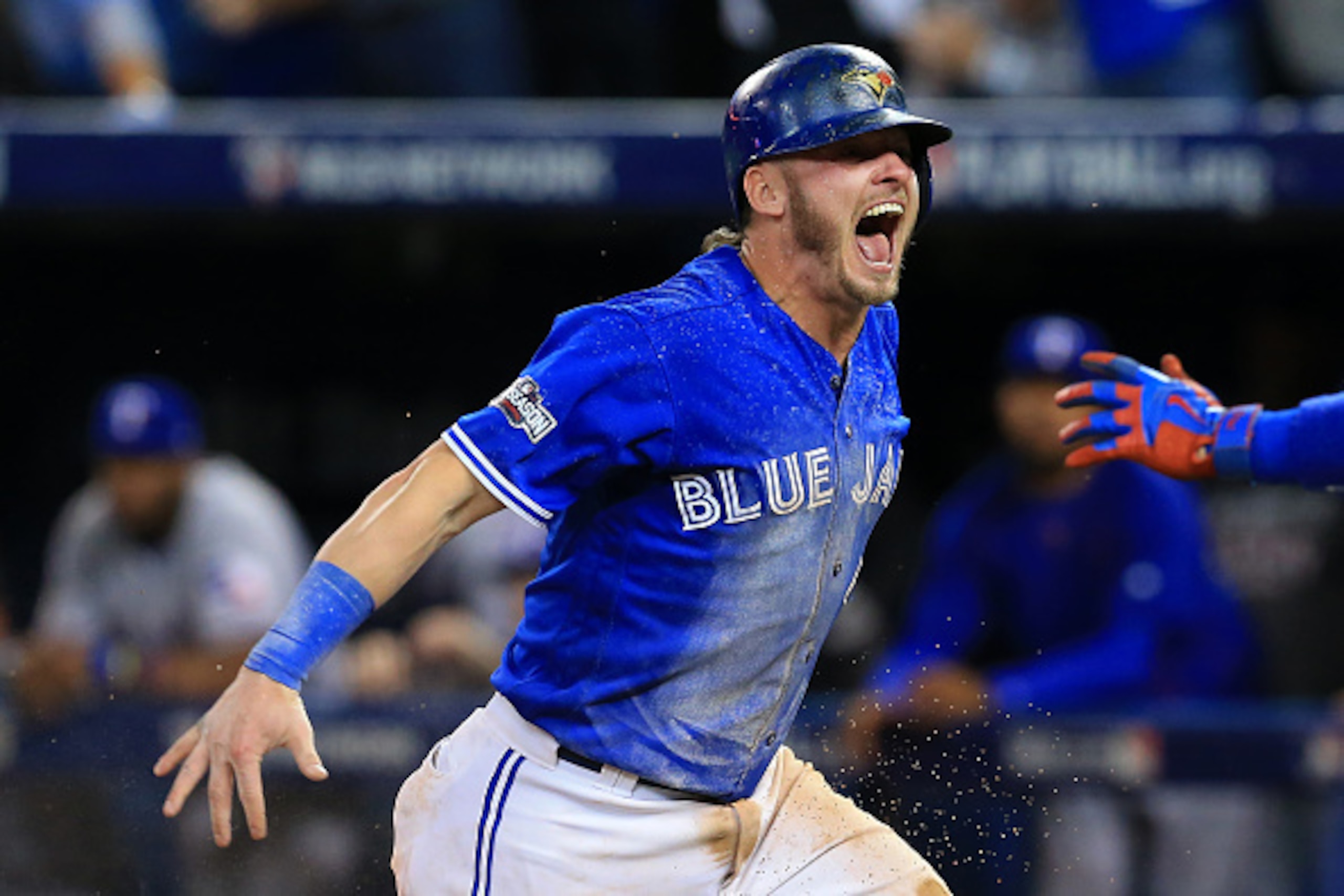 TORONTO, ON - OCTOBER 9: Josh Donaldson #20 of the Toronto Blue Jays celebrates after sliding safely into home plate in the tenth inning for the Toronto Blue Jays to defeat the Texas Rangers 7-6 for game three of the American League Division Series at Rog