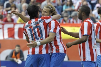 Athletico Madrid's Uruguayan forward Diego Forlan (C) is congratuled by his teammates Argentinian forward Kun Aguero (L) and French forward Florent Sinama Pongolle (R) after scoring during the Spanish League football match against Osasuna at the Vicente C