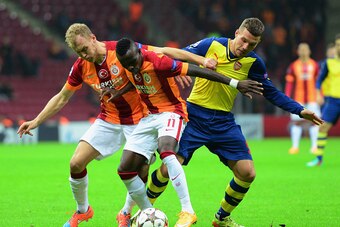 ISTANBUL, TURKEY - DECEMBER 09:  Lukas Podolski of Arsenal battles with Bruma (11) and Semih Kaya (L) of Galatasaray during the UEFA Champions League Group D match between Galatasaray AS and Arsenal FC at Ali Sami Yen Arena on December 9, 2014 in Istanbul