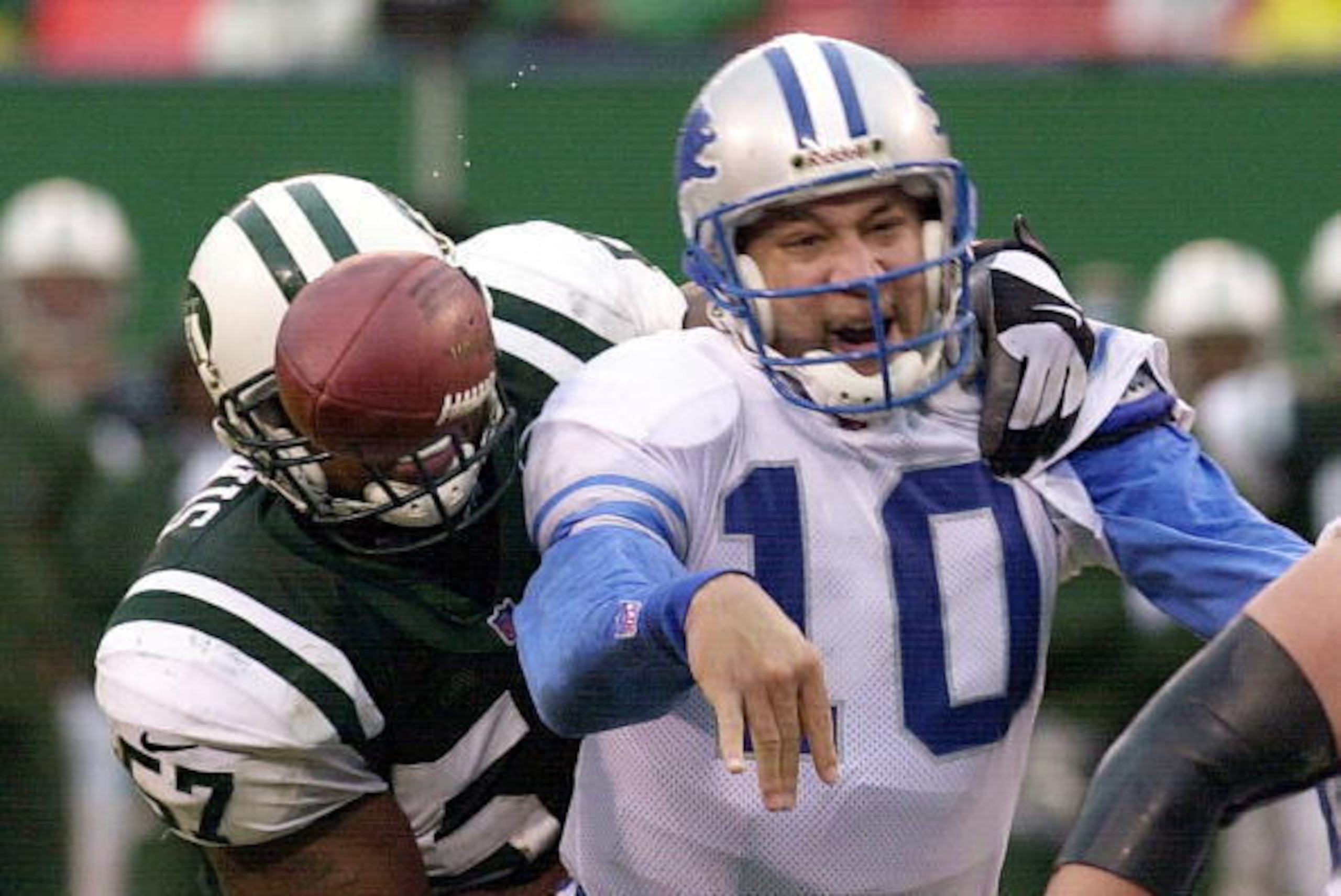 EAST RUTHERFORD, UNITED STATES:  Detroit Lions' quarterback Charlie Batch (R) gets hit by the New York Jets' Moe Lewis (L) as he releases the ball in the second quarter at Giants Stadium in East Rutherford, New Jersey 17 December, 2000.  AFP PHOTO/Henny R