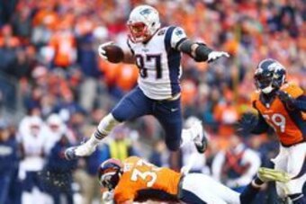 Jan 24, 2016; Denver, CO, USA; New England Patriots tight end Rob Gronkowski (87) leaps over Denver Broncos defensive back Shiloh Keo (33) in the second half in the AFC Championship football game at Sports Authority Field at Mile High. Mandatory Credit: M