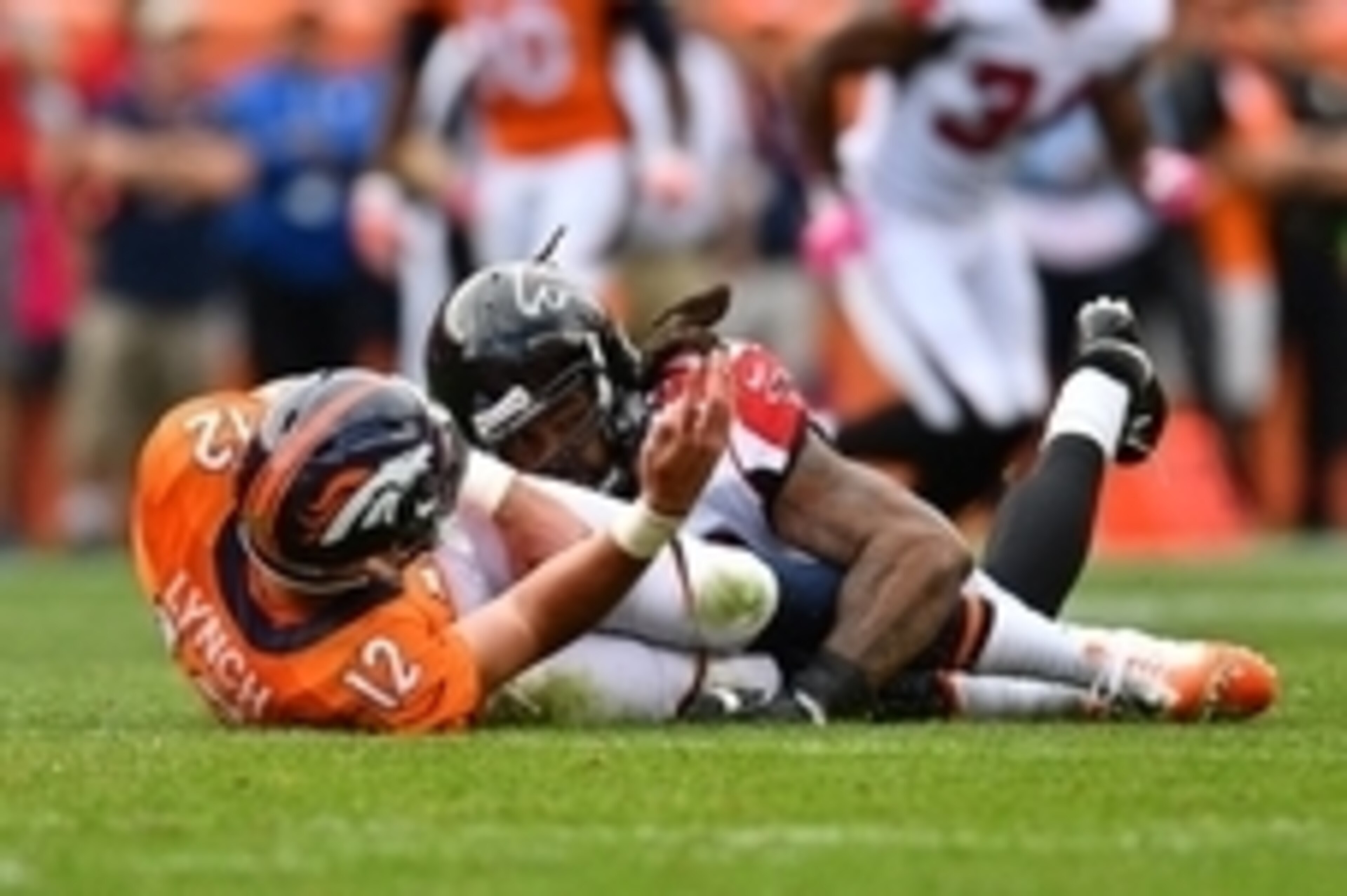 Oct 9, 2016; Denver, CO, USA; Denver Broncos quarterback Paxton Lynch (12) is tackled to the turf by Atlanta Falcons defensive end Adrian Clayborn (99) in the second half at Sports Authority Field at Mile High. The Falcons defeated the Broncos 23-16. Mand