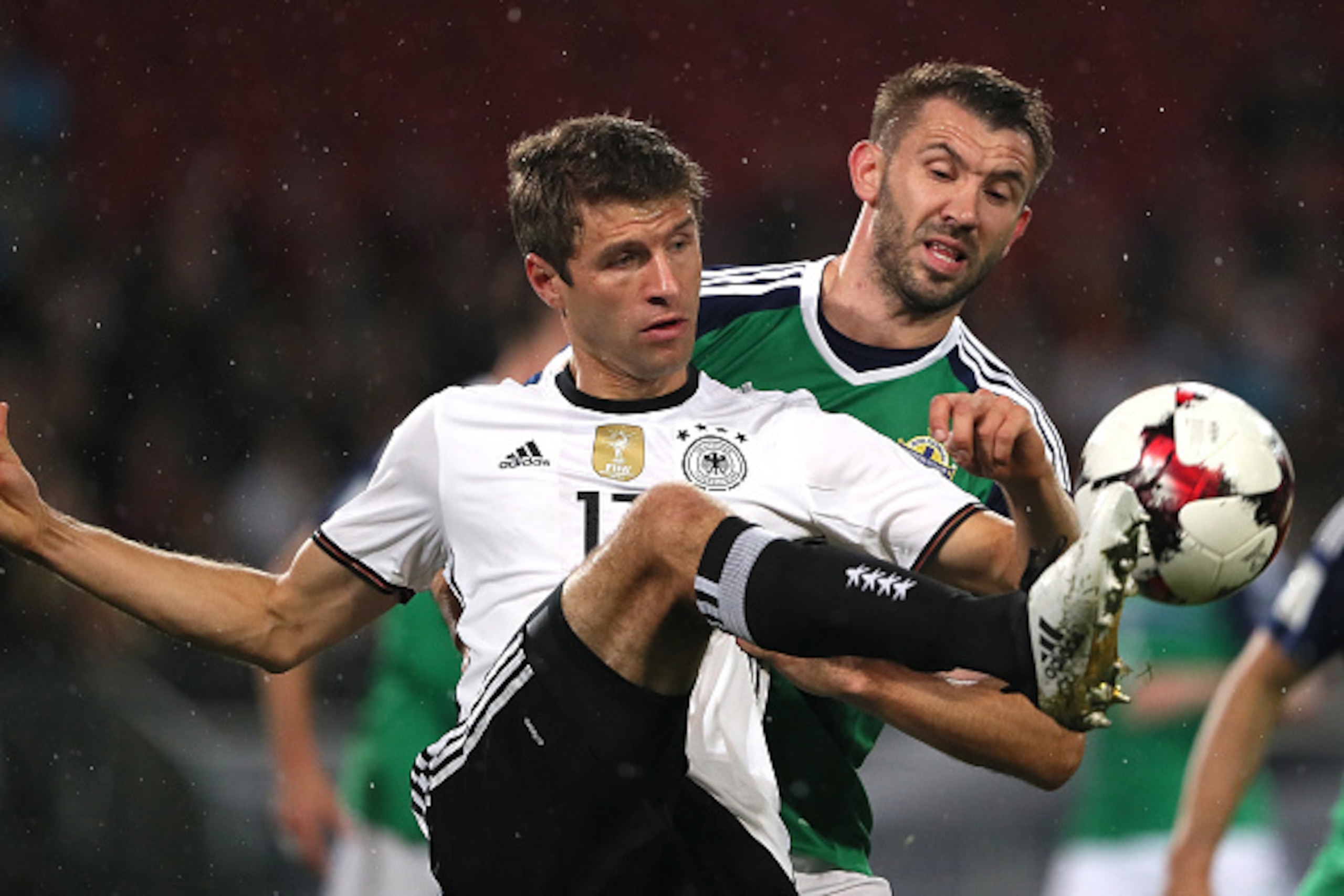 HANOVER, GERMANY - OCTOBER 11:  Thomas Muller of Germany competes with Gareth McAuley of Northern Ireland during the FIFA 2018 World Cup Qualifier between Germany and Northern Ireland at HDI-Arena on October 11, 2016 in Hanover, Germany.  (Photo by Matthe
