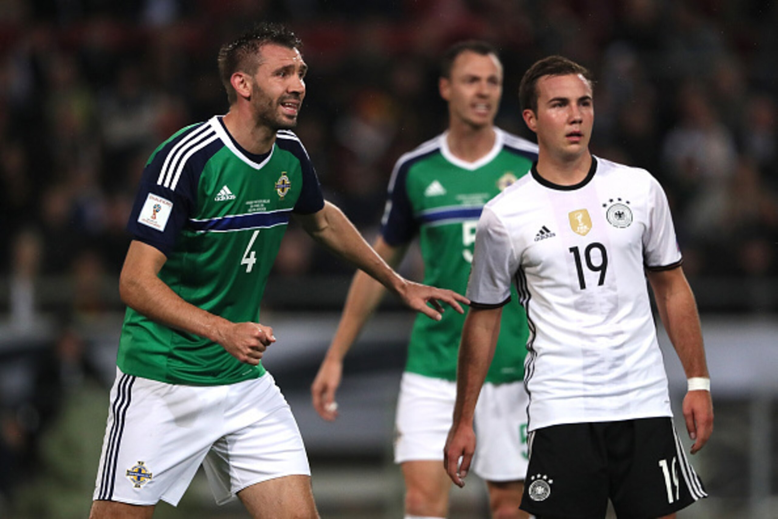 HANOVER, GERMANY - OCTOBER 11:  Mario Goetze of Germany competes with Gareth McAuley and Jonny Evans of Northern Ireland during the FIFA 2018 World Cup Qualifier between Germany and Northern Ireland at HDI-Arena on October 11, 2016 in Hanover, Germany.  (