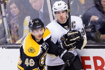 BOSTON, MA - NOVEMBER 25: Sidney Crosby #87 of the Pittsburgh Penguins gets checked into the boards by David Krejci #46 of the Boston Bruins during the third period of an NHL hockey game on November 25, 2013 at TD Garden in Boston, Massachusetts. (Photo b