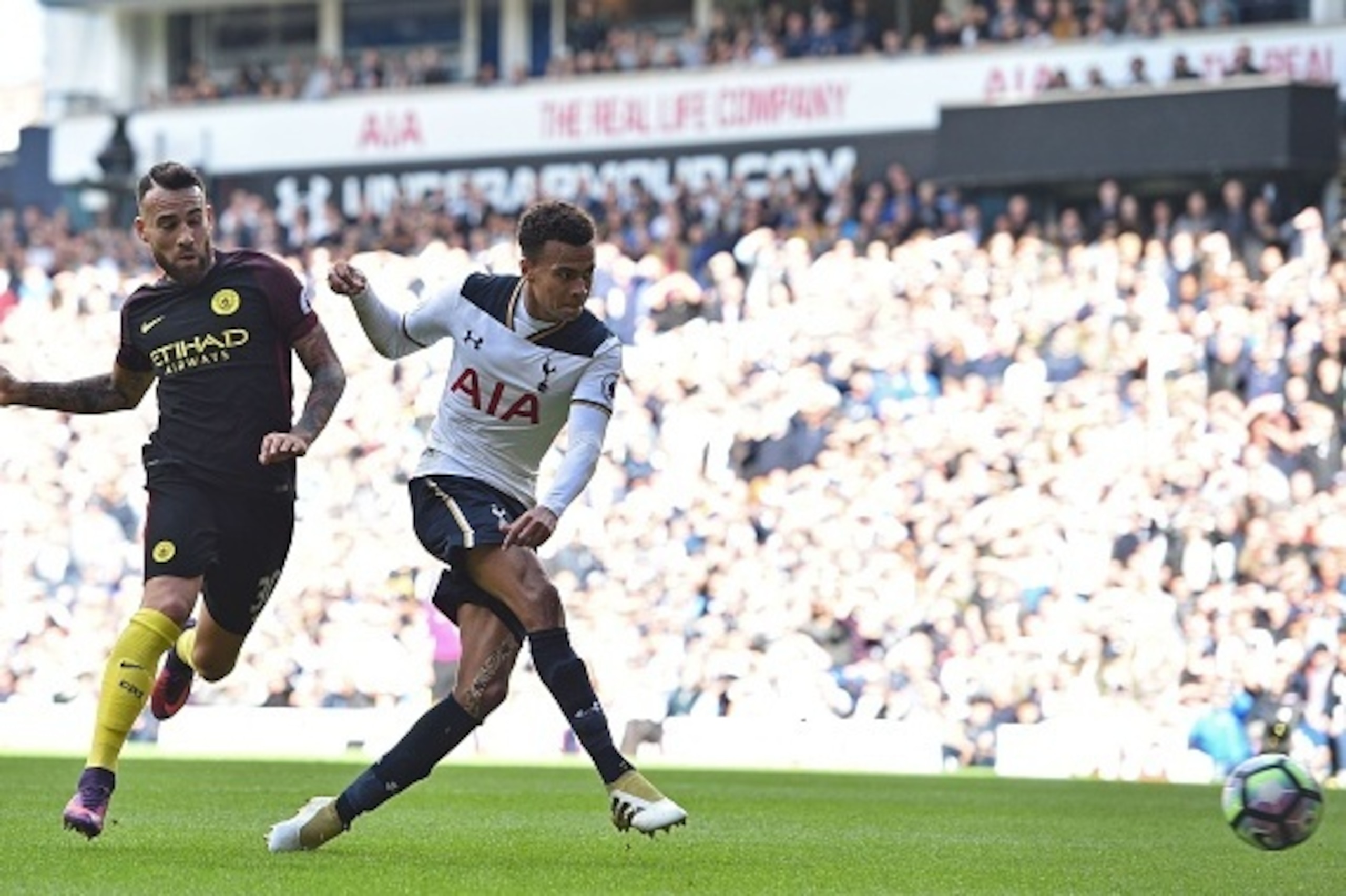 Tottenham Hotspur's English midfielder Dele Alli shoots to score their second goal under pressure from Manchester City's Argentinian defender Nicolas Otamendi (L) during the English Premier League football match between Tottenham Hotspur and Manchester Ci