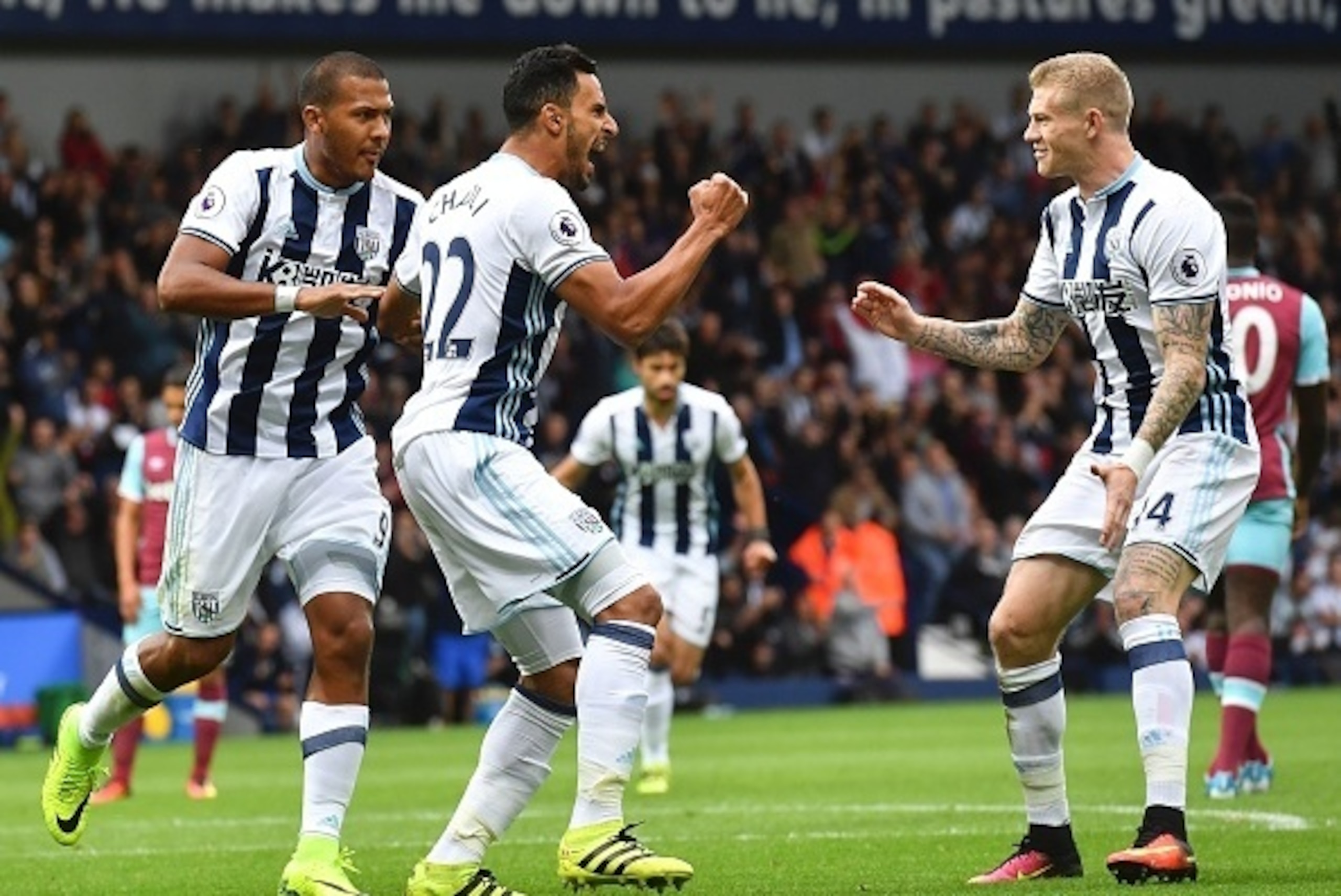 West Bromwich Albion's Belgian midfielder Nacer Chadli (2L) celebrates with Irish midfielder James McClean (R) after scoring a penalty for the opening goal during the English Premier League football match between West Bromwich Albion and West Ham United a