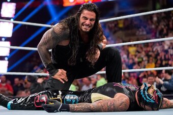 Roman Reigns towers over Rey Mysterio after spearing him at Survivor Series.