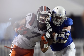 SHREVEPORT, LA - DECEMBER 26:  Bucky Hodges #7 of the Virginia Tech Hokies is hit by Derrick Luetjen #99 of the Tulsa Golden Hurricane during the second half of the Camping World Independence Bowl on December 26, 2015 in Shreveport, Louisiana.  (Photo by 