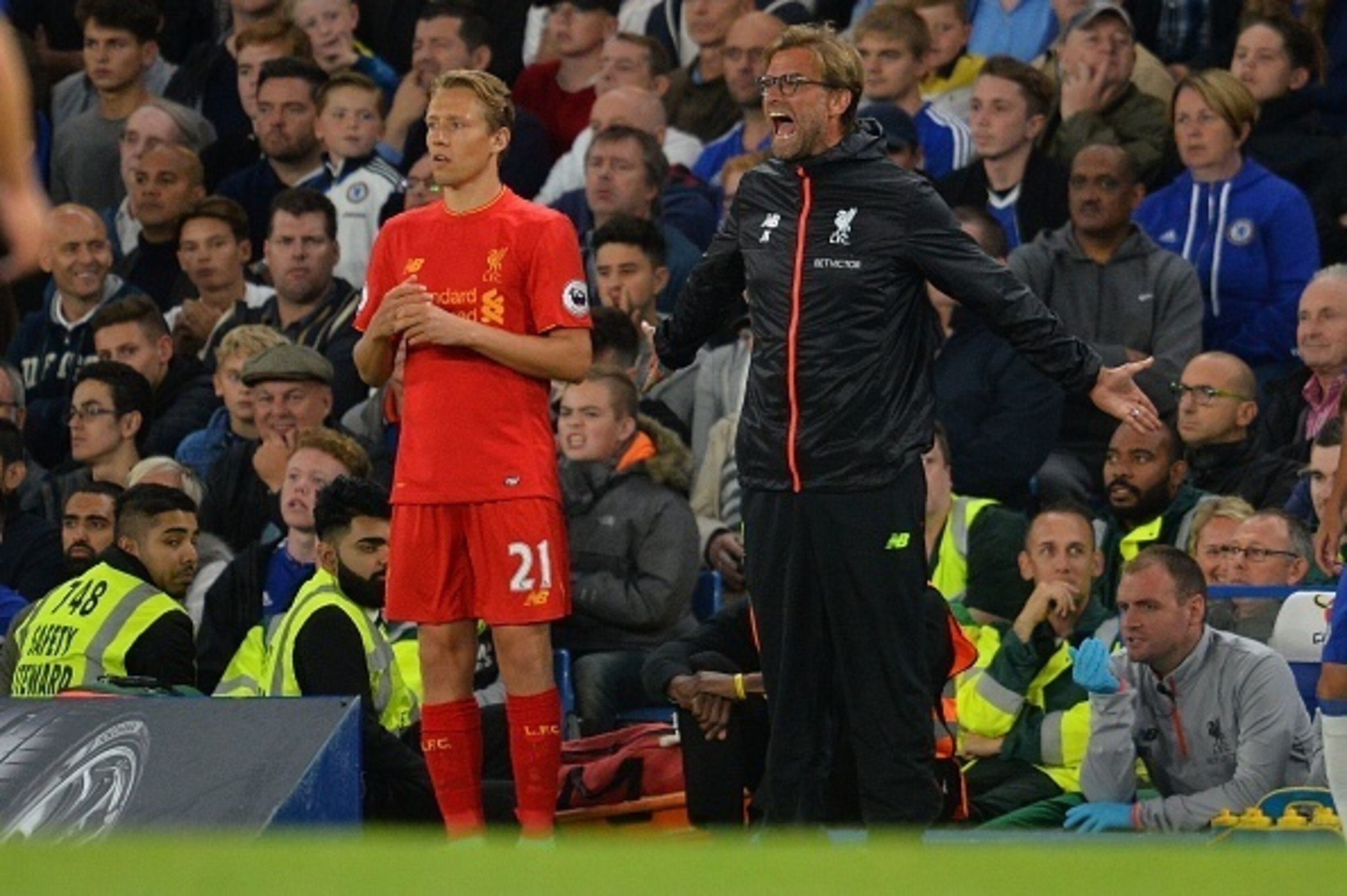 Liverpool's Brazilian midfielder Lucas Leiva (L) stands alongside  Liverpool's German manager Jurgen Klopp as Klopp shouts instructions to his players from the touchline during the English Premier League football match between Chelsea and Liverpool at Sta