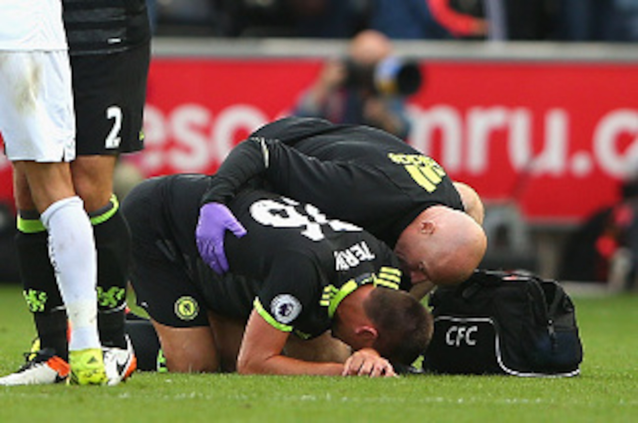 SWANSEA, WALES - SEPTEMBER 11:  Jack Cork of Swansea City and Branislav Ivanovic of Chelsea embrace as John Terry of Chelsea is given treatment after the Premier League match between Swansea City and Chelsea at Liberty Stadium on September 11, 2016 in Swa