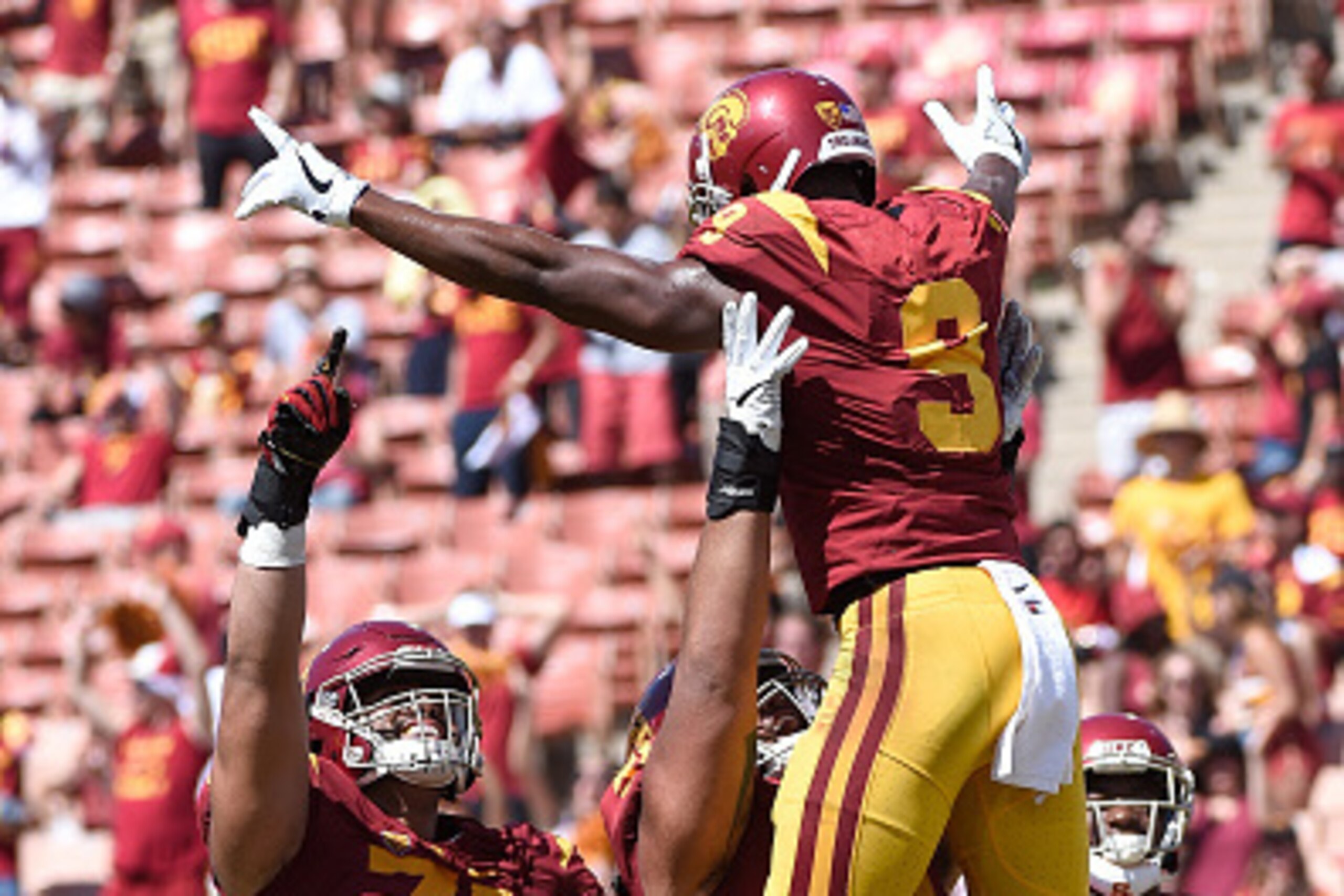LOS ANGELES, CA - SEPTEMBER 10:  (Right) JuJu Smith-Schuster #9 of the USC Trojans celebrates with teammates Nico Falah #74 and Damien Mama #51 after scoring a touchdown in the 4th quarter against the Utah State Aggies at Los Angeles Coliseum on September