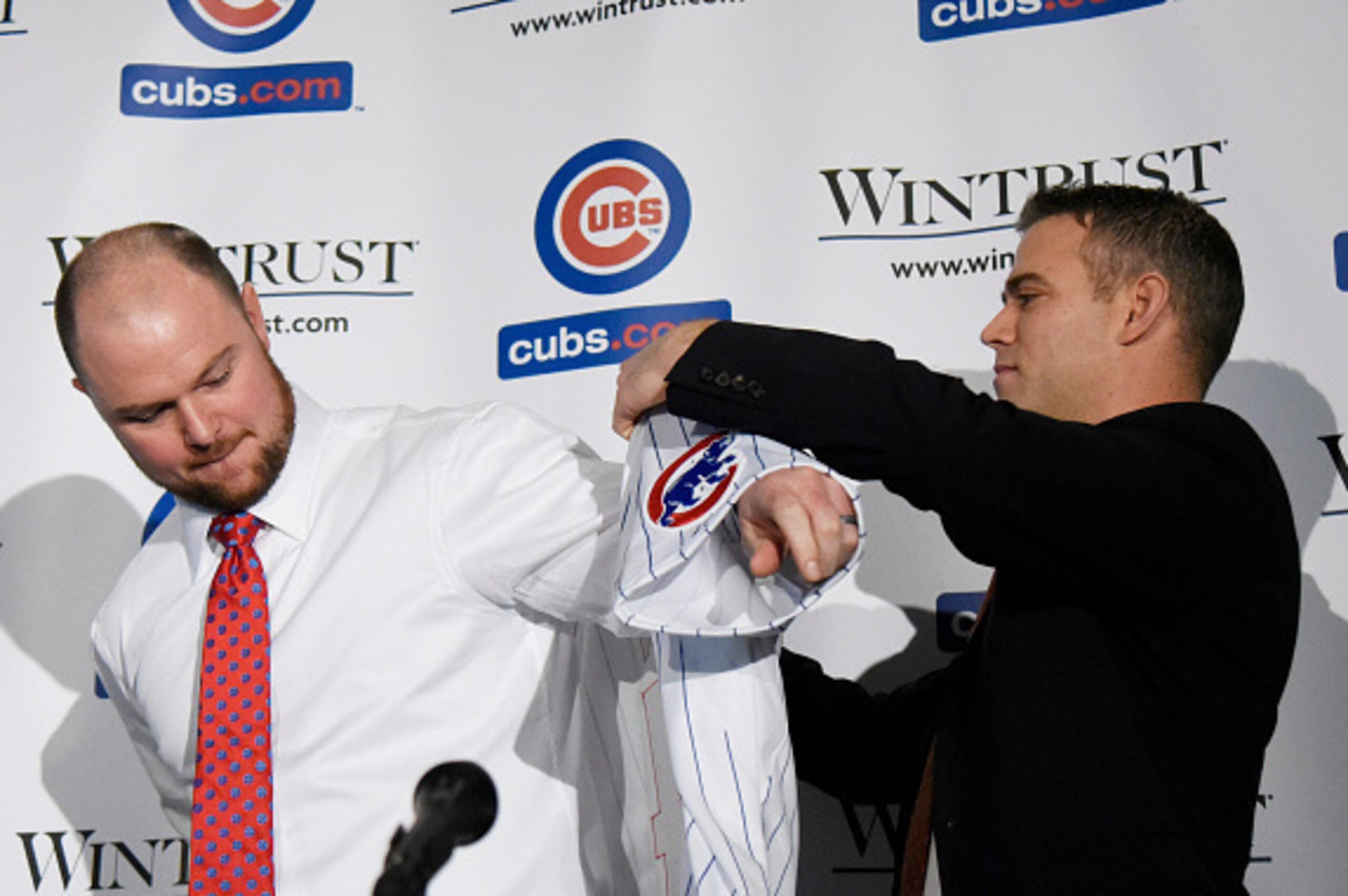 CHICAGO, IL - DECEMBER 15:  Pitcher Jon Lester (L) outs on a Cubs jersey the he was presented by Chicago Cubs President Theo Epstein during an introduction press conference on December 15, 2014  in Chicago, Illinois. (Photo by David Banks/Getty Images)