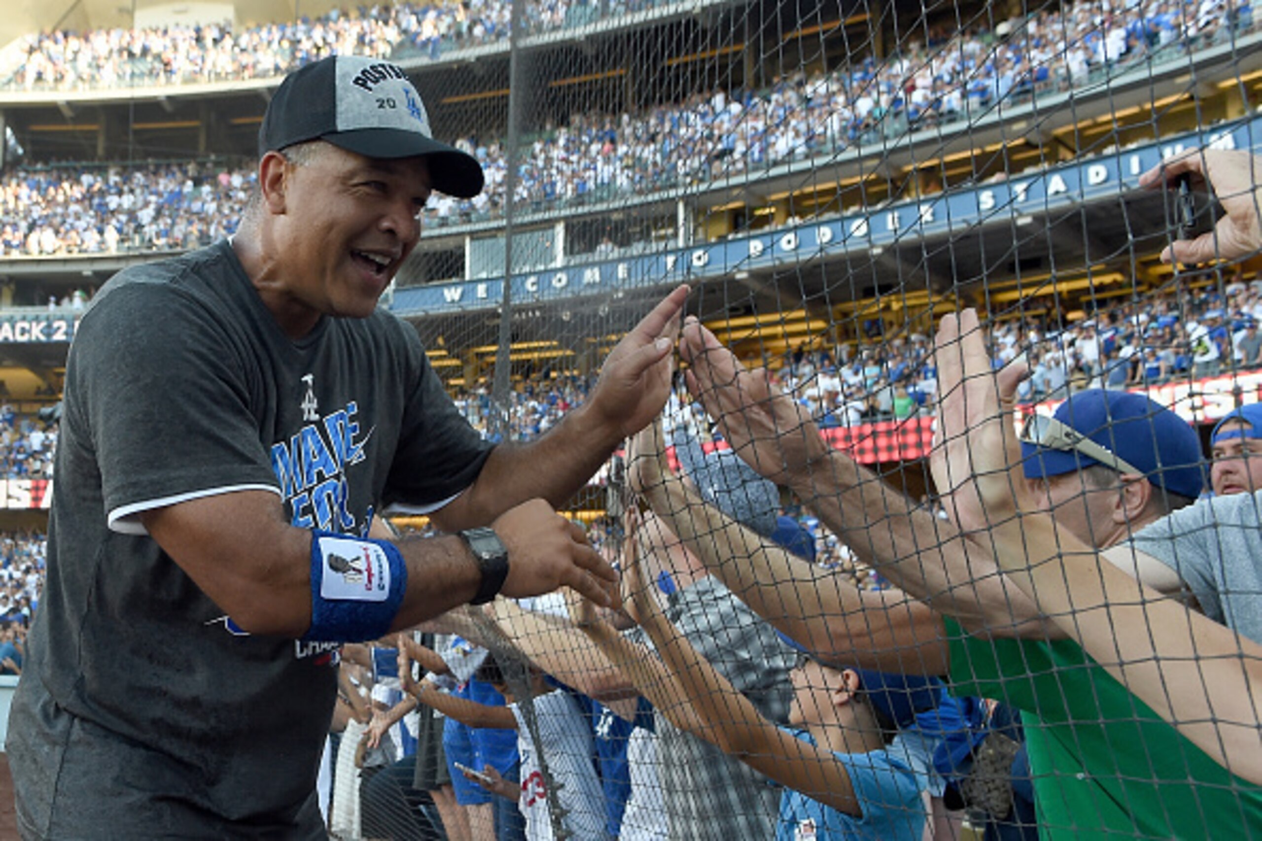 LOS ANGELES, CA - SEPTEMBER 25:  Manager Dave Roberts of the Los Angeles Dodgers celebrates with fans after a 4-3 win over the Colorado Rockies at Dodger Stadium on September 25, 2016 in Los Angeles, California. The Los Angeles Dodgers clinch the division