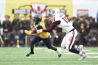 MEMPHIS, TN - DECEMBER 29:  Jordan Thompson #10 of the West Virginia Mountaineers is brought down by Myles Garrett #15 of the Texas A&M Aggies during the 56th annual Autozone Liberty Bowl at Liberty Bowl Memorial Stadium on December 29, 2014 in Memphis, T