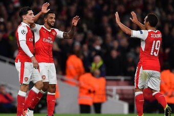 Arsenal's English midfielder Theo Walcott (C) celebrates scoring his team's second goal with Arsenal's Spanish defender Hector Bellerin (L) and Arsenal's Spanish midfielder Santi Cazorla during the UEFA Champions League Group A football match between Arse