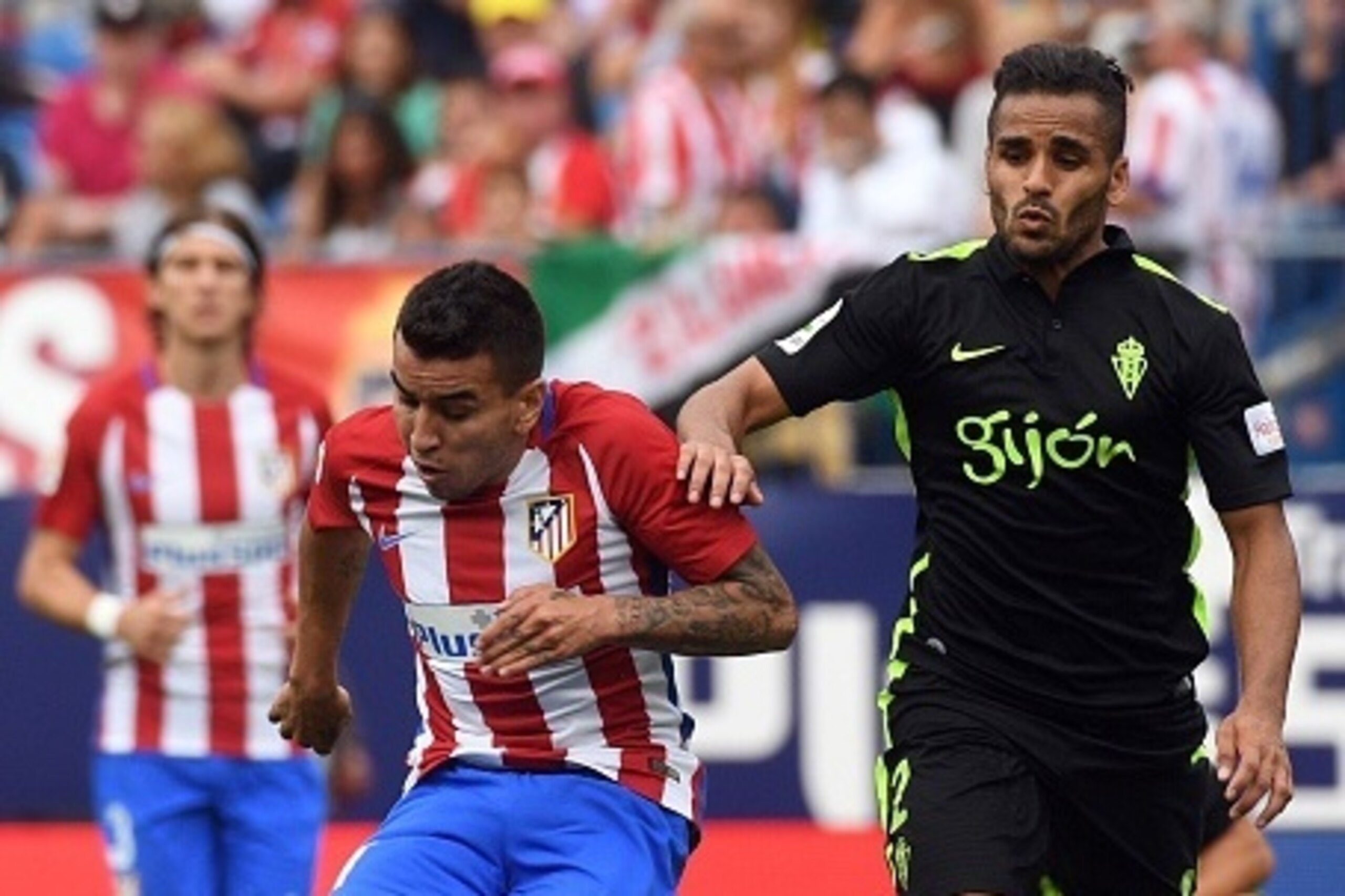 Atletico Madrid's Argentinian forward Angel Correa (L) kicks the ball past Sporting Gijon's Brazilian defender Douglas during the Spanish league football match Club Atletico de Madrid vs Real Sporting de Gijon at the Vicente Calderon stadium in Madrid on 