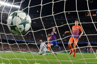 Barcelona's Argentinian forward Lionel Messi (C) scores a goal beside Manchester City's defender John Stones (R) during the UEFA Champions League football match FC Barcelona vs Manchester City at the Camp Nou stadium in Barcelona on October 19, 2016. / AF