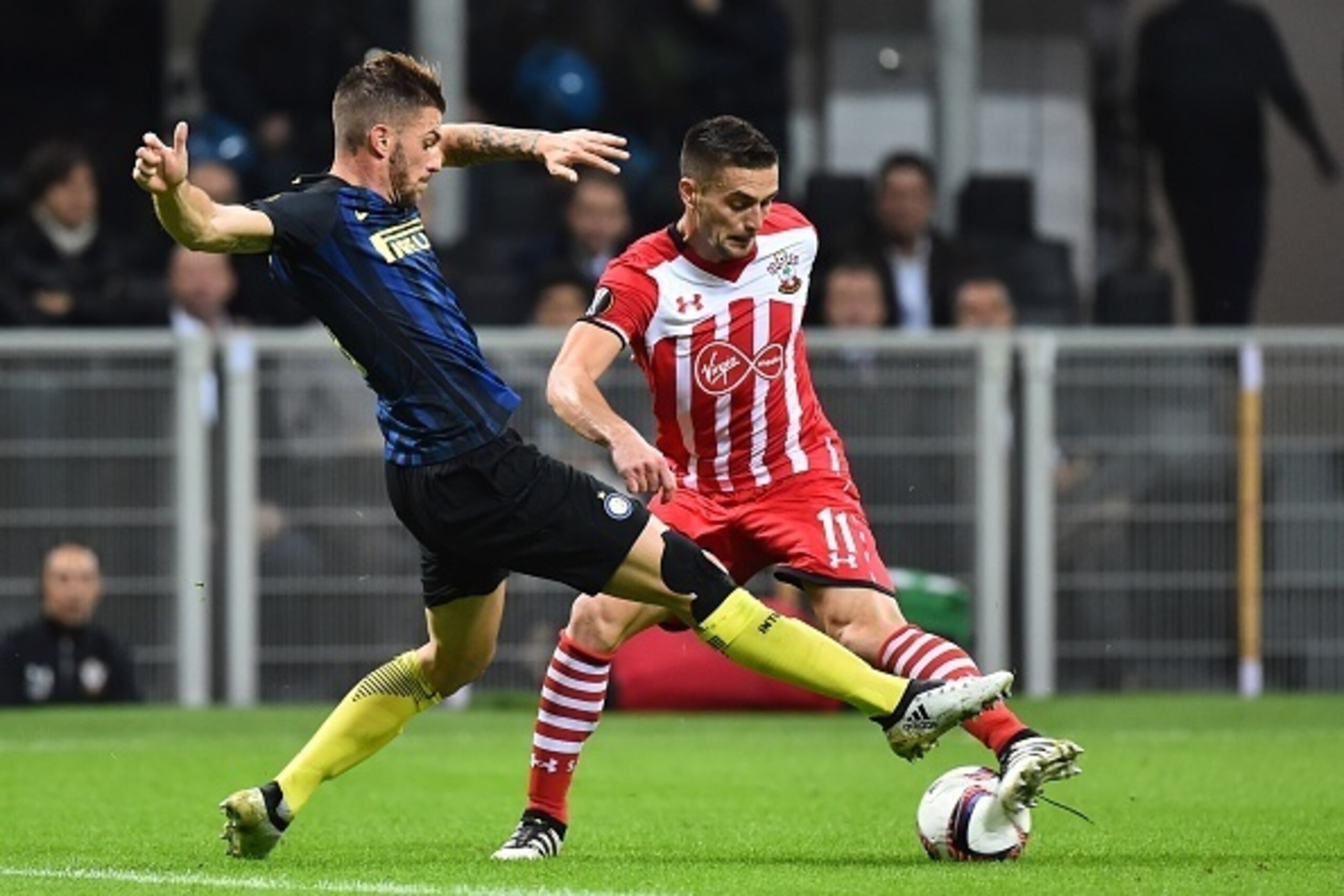 Inter Milan's Italian defender Davide Santon (L) challenges Southampton's Serbian forward Dusan Tadic during the Europa League group K football match between Inter and Southampton at the San Siro Stadium in Milan on October 20, 2016. / AFP / GIUSEPPE CACA
