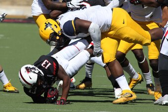 Oct 15, 2016; Lubbock, TX, USA;  Texas Tech Red Raiders running back Cameron Batson (13) is driven to the ground by West Virginia Mountaineers defensive lineman David Long (11) at Jones AT&T Stadium. West Virginia defeated Texas Tech 48-17. Mandatory Cred