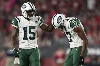 GLENDALE, AZ - OCTOBER 17:  Wide receiver Brandon Marshall #15 of the New York Jets helps Charone Peake #17 after Peake was injured during the third quarter of the NFL game against the Arizona Cardinals at the University of Phoenix Stadium on October 17, 