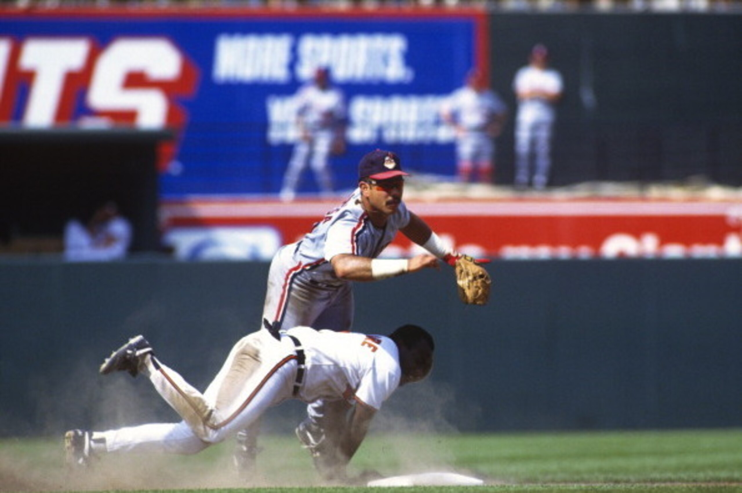 BALTIMORE, MD - CIRCA 1992: Carlos Baerga #9 of the Cleveland Indians gets his throw off to first base while avoiding the slide of Mark McLemore #2 of the Baltimore Orioles during an Major League Baseball game circa 1992 at Orioles Park at Camden Yards in