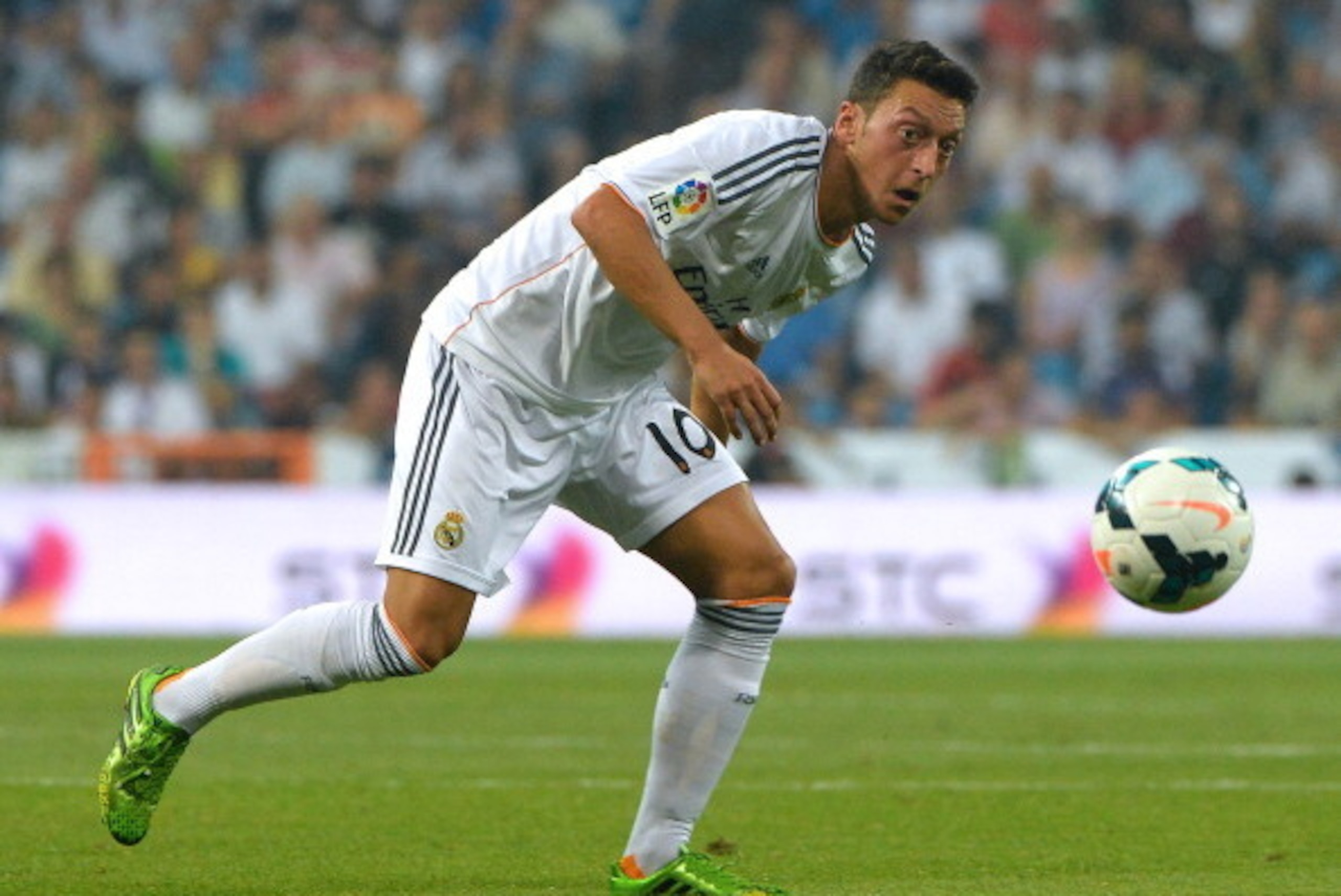 Real Madrid's German midfielder Mesut Ozil eyes the ball during the Spanish league football match Real Madrid CF vs Real Betis at the Santiago Bernabeu stadium in Madrid on August 18, 2013. Real Madrid won 2-1.  AFP PHOTO / GERARD JULIEN        (Photo cre
