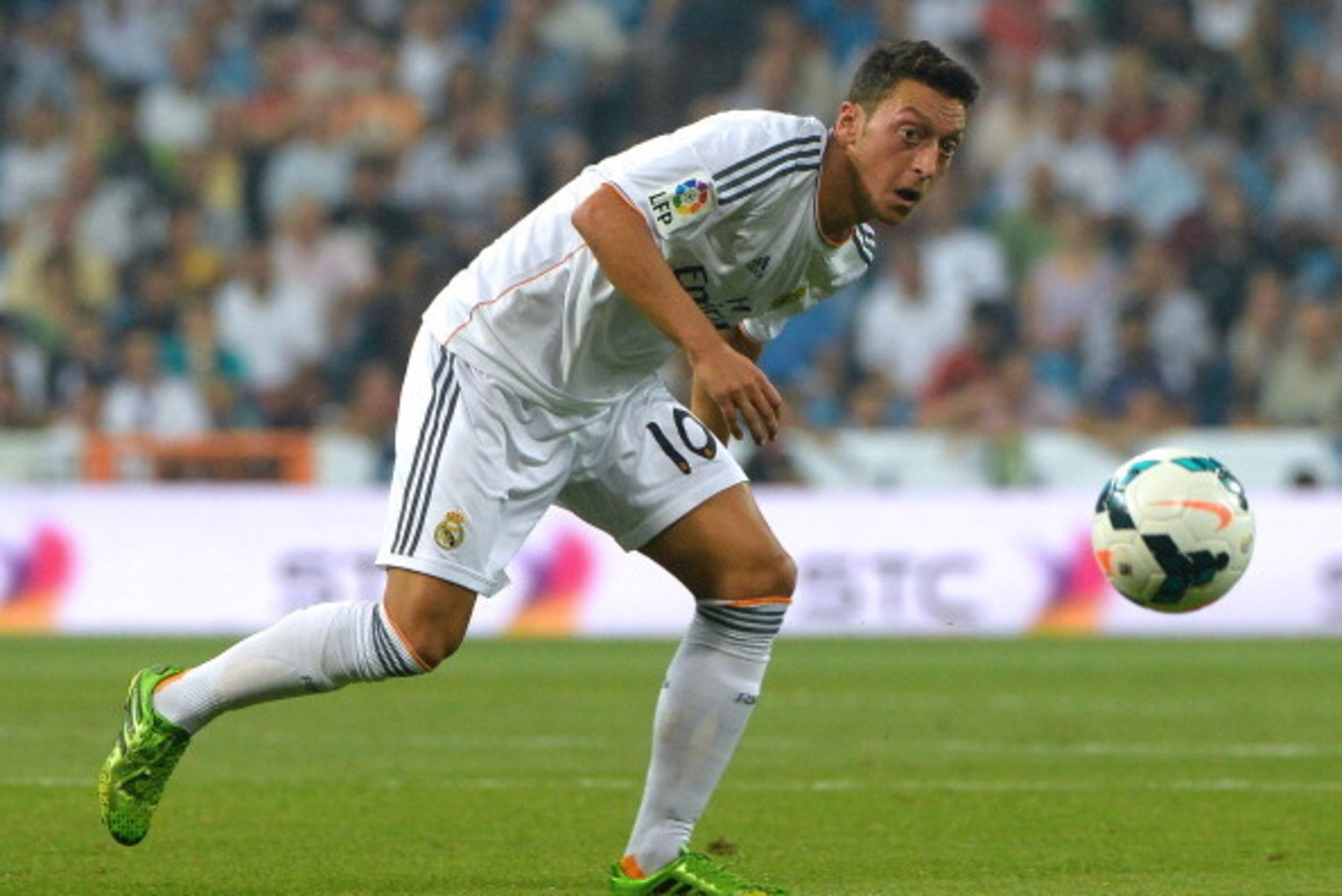 Real Madrid's German midfielder Mesut Ozil eyes the ball during the Spanish league football match Real Madrid CF vs Real Betis at the Santiago Bernabeu stadium in Madrid on August 18, 2013. Real Madrid won 2-1.  AFP PHOTO / GERARD JULIEN        (Photo cre