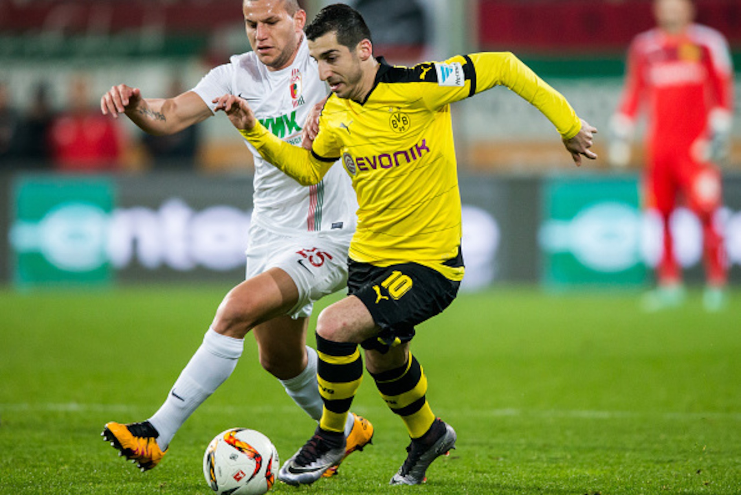 AUGSBURG, GERMANY - MARCH 20:  Henrikh Mkhitaryan of Dortmund is challenged by Raul Bobadilla of Augsburg during the Bundesliga match between FC Augsburg and Borussia Dortmund at SGL Arena on March 20, 2016 in Augsburg, Germany.  (Photo by Simon Hofmann/G