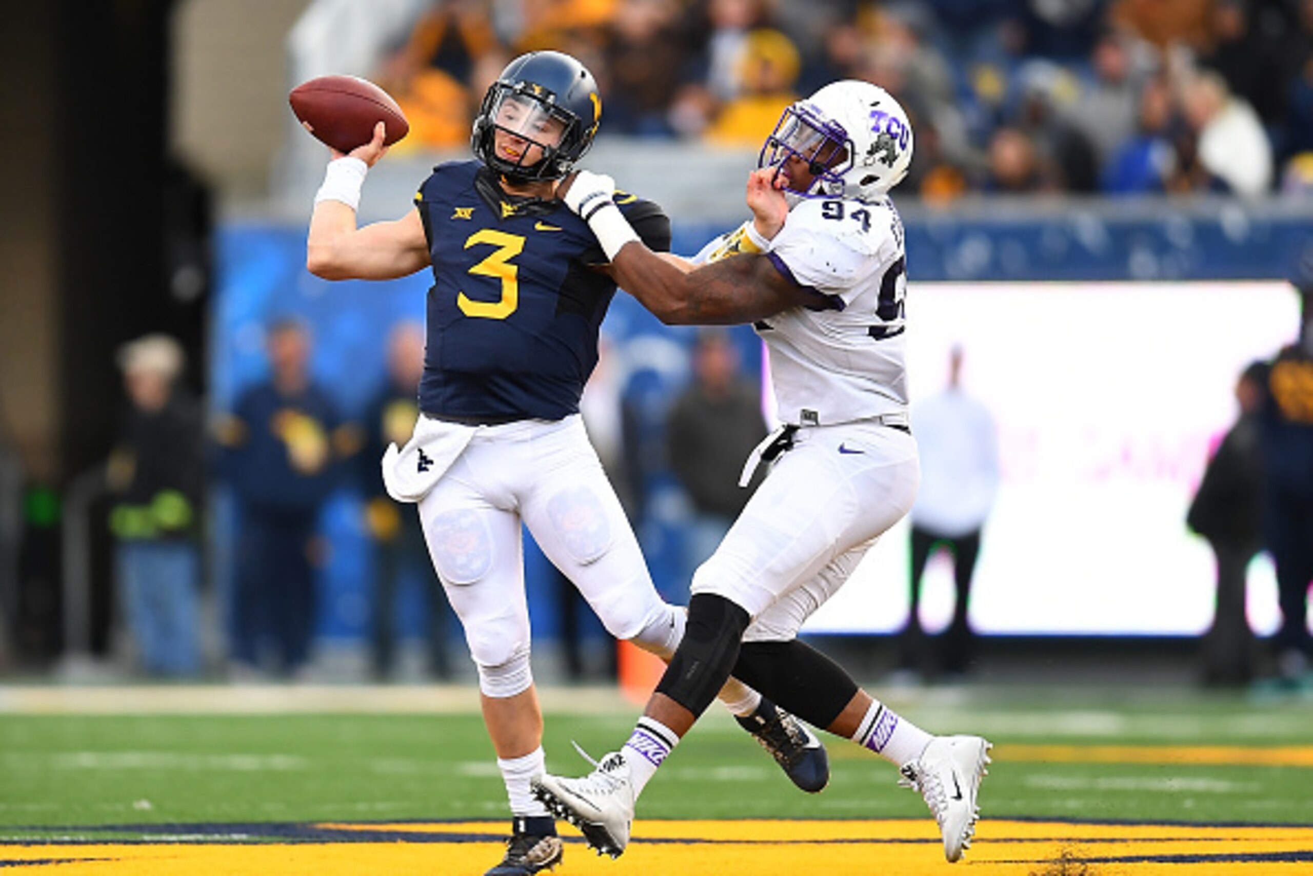 MORGANTOWN, WV - OCTOBER 22:  Skyler Howard #3 of the West Virginia Mountaineers throws a pass in front of the defense of Josh Carraway #94 of the TCU Horned Frogs during the second quarter at Mountaineer Field on October 22, 2016 in Morgantown, West Virg