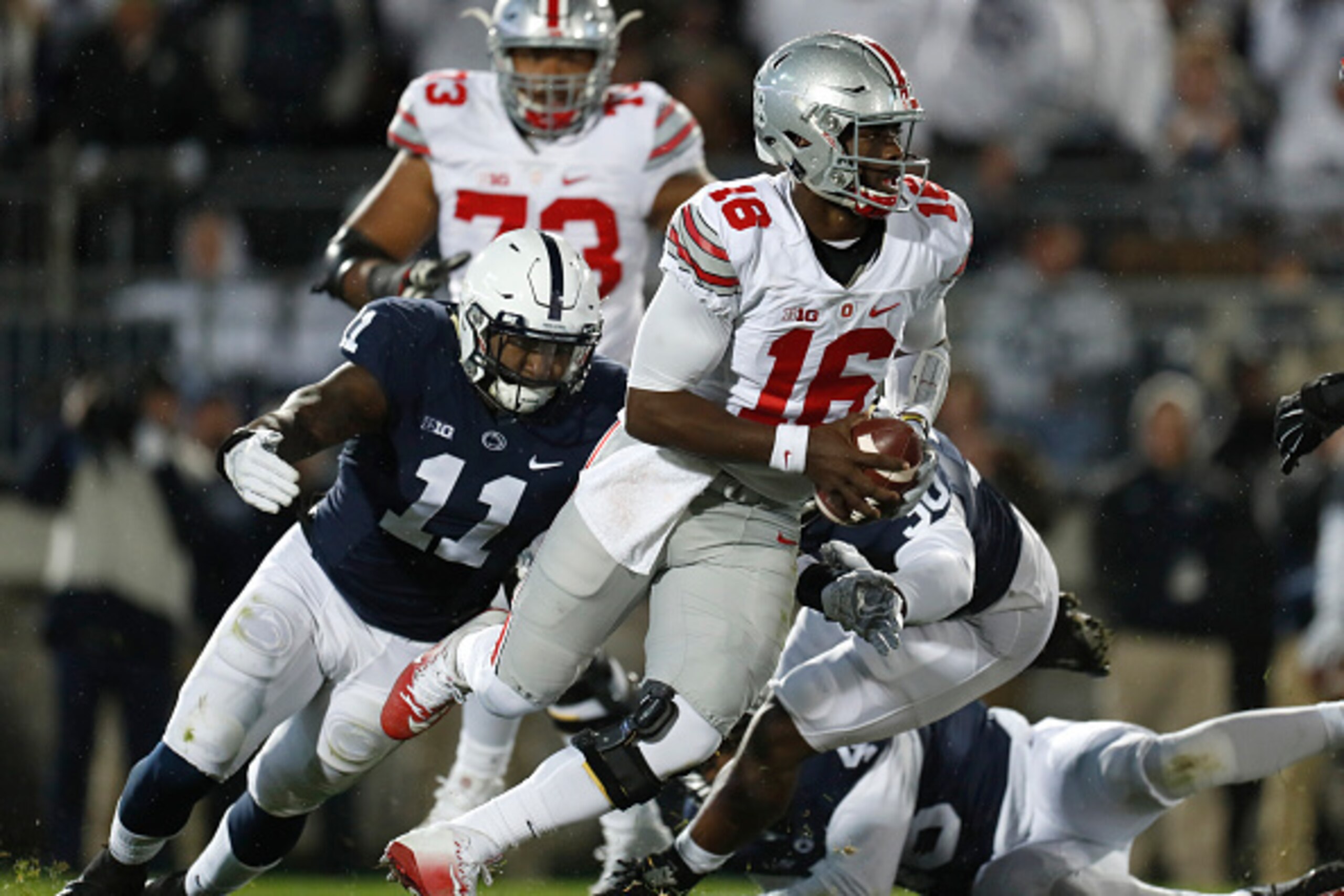 STATE COLLEGE, PA - OCTOBER 22:  J.T. Barrett #16 of the Ohio State Buckeyes is hurried by Brandon Bell #11 of the Penn State Nittany Lions in the first half during the game on October 22, 2016 at Beaver Stadium in State College, Pennsylvania.  (Photo by 