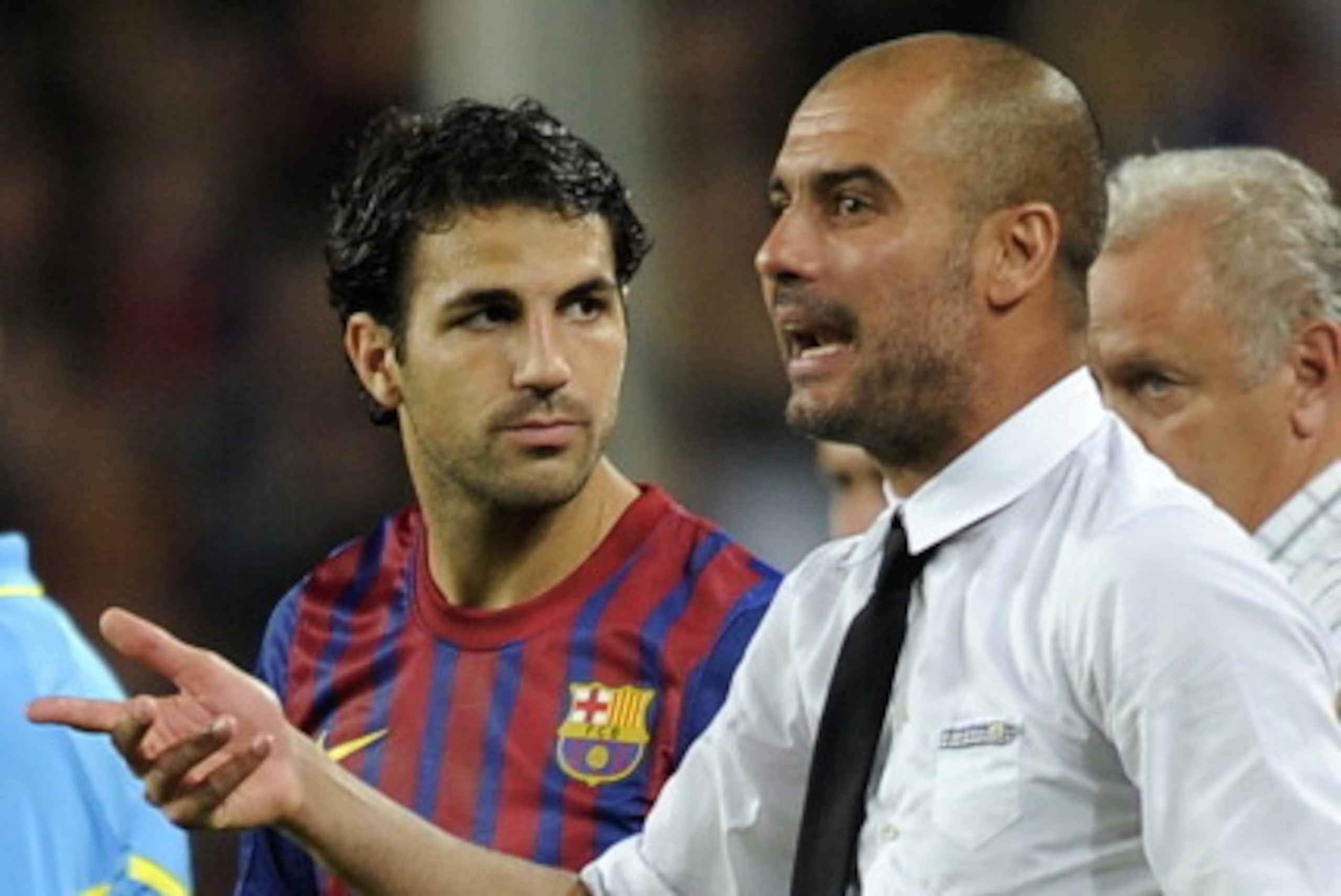 Barcelona's coach Josep Guardiola (R) gives instructions to Barcelona's Cesc Fabregas during the second leg of the Spanish Supercup football match FC Barcelona vs Real Madrid CF on August 17, 2011 at the Camp Nou stadium in Barcelona. Barcelona won the Sp