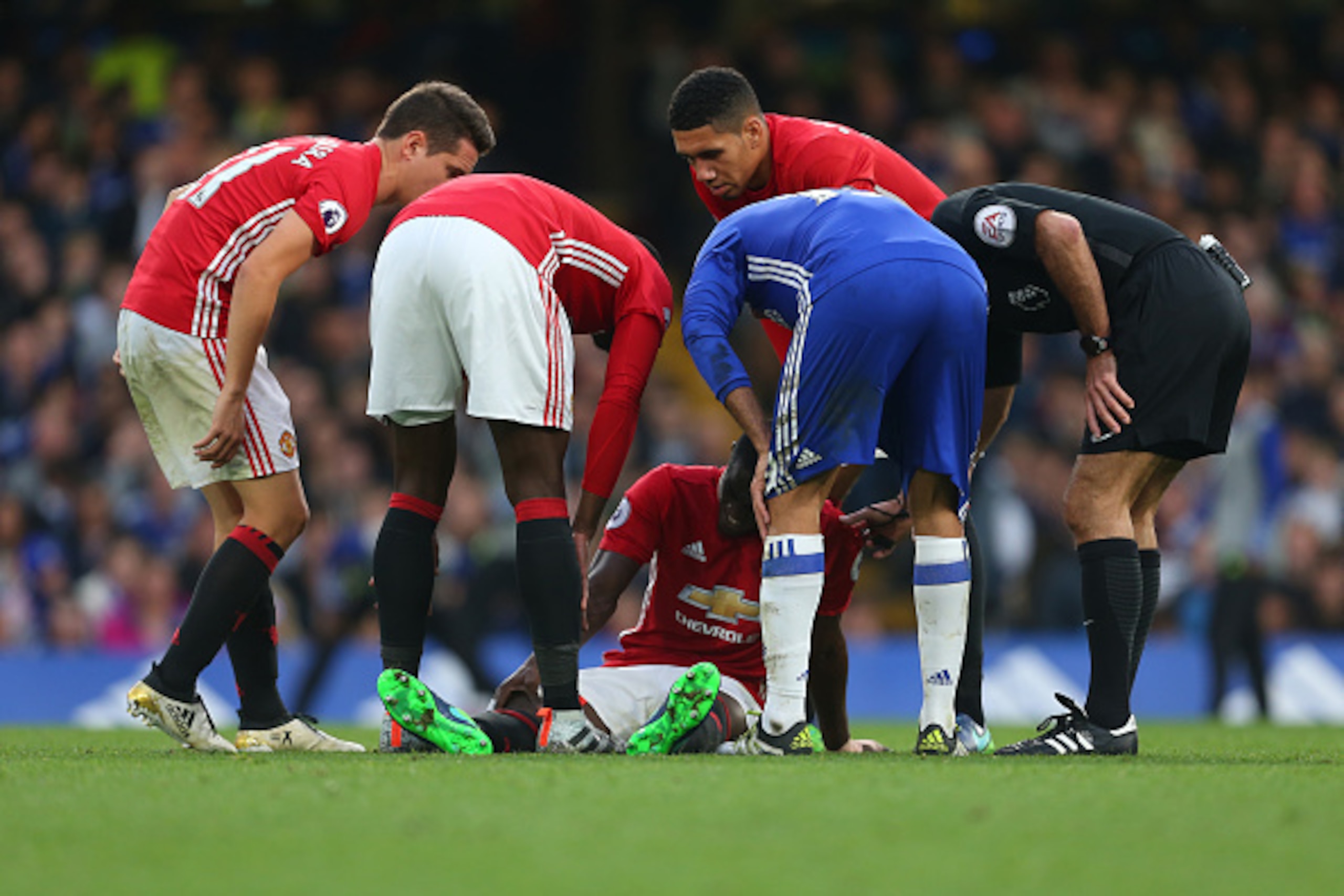 LONDON, ENGLAND - OCTOBER 23: The players check on an injured Eric Bailly of Manchester United during the Premier League match between Chelsea and Manchester United at Stamford Bridge on October 23, 2016 in London, England. (Photo by Catherine Ivill - AMA