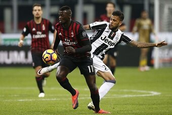 AC Milan's French forward Mbaye Niang (L) vies with Juventus' Brazilian defender Daniel Alves during the Italian Serie A football match AC Milan versus Juventus on October 22, 2016 at the San Siro Stadium in Milan.  / AFP / MARCO BERTORELLO        (Photo 